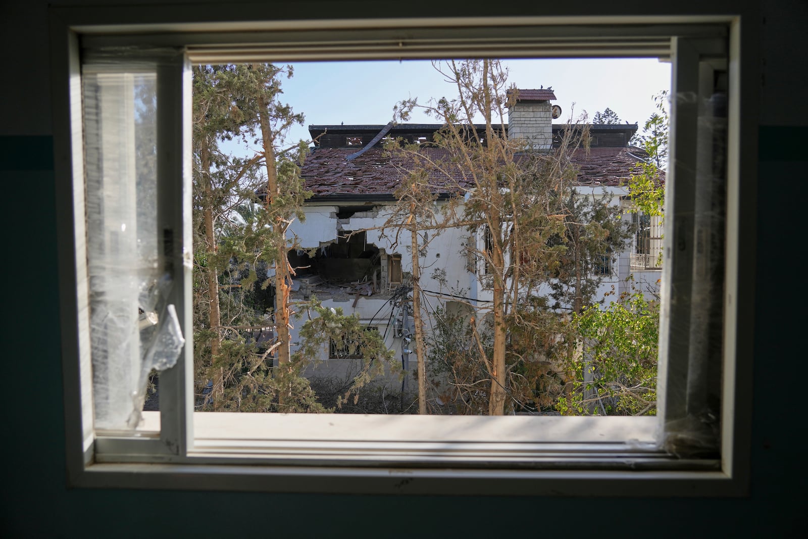 The impact of a projectile is visible on the wall of the U.N. guesthouse, where United Nations workers were located when the building was struck, leaving one staff member dead and five others injured in Deir al-Balah, central Gaza, Wednesday, March 19, 2025. (AP Photo/Abdel Kareem Hana)