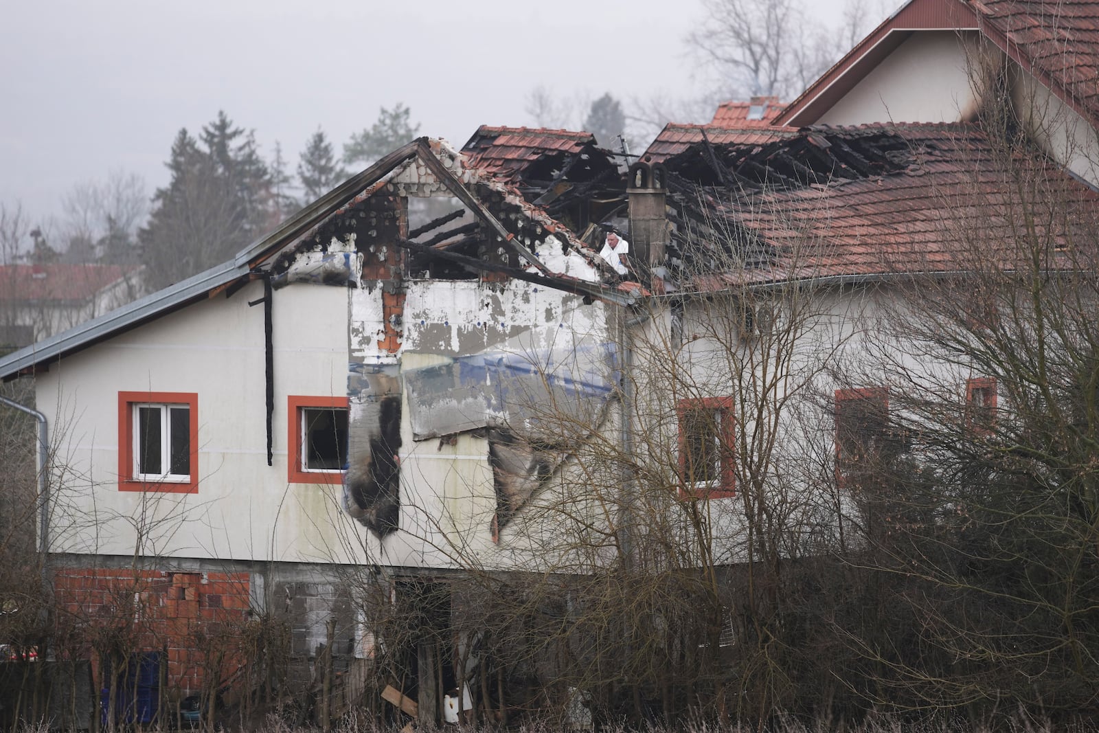 Police officers inspect a home for the elderly where eight people died in a fire, in Barajevo, a municipality of Belgrade, Serbia, Monday, Jan. 20, 2025. (AP Photo/Darko Vojinovic)