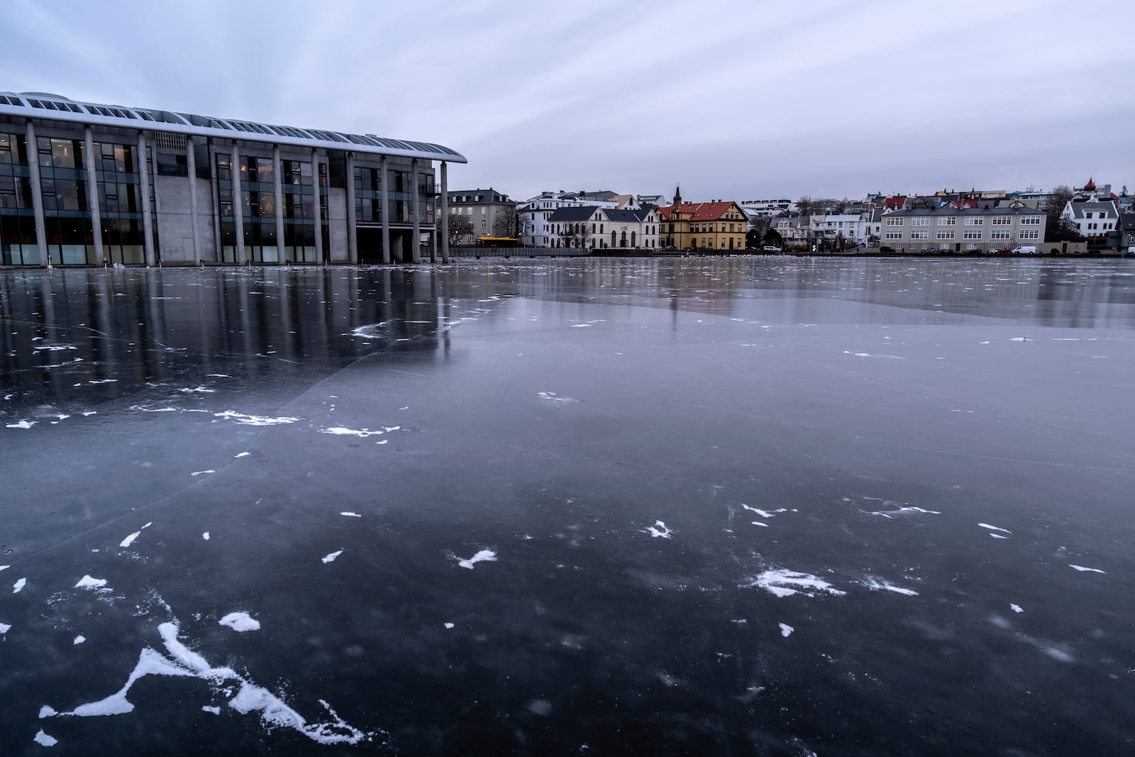 A view of Tjörnin, the city pond completely frozen, with the city hall at left, and downtown Reykjavik in the background, Friday, Nov. 29, 2024. (AP Photo Marco Di Marco)