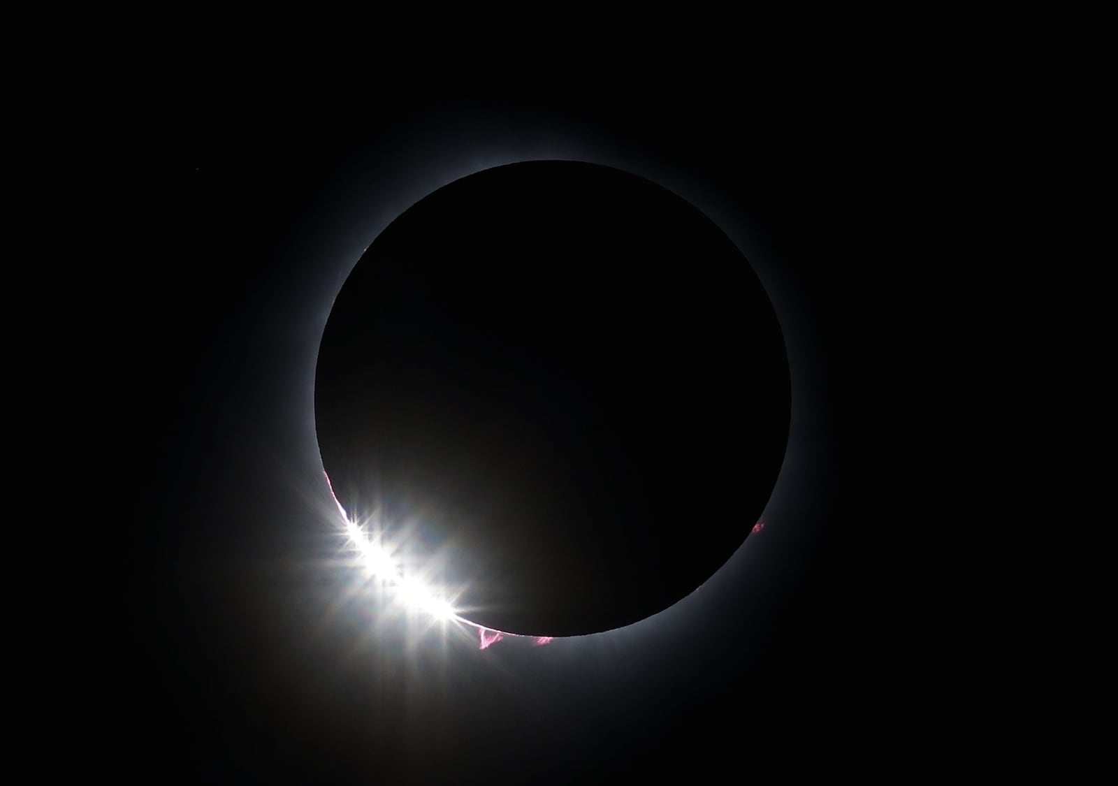 Totality phase is visible as hundreds gather to view the total solar eclipse Monday morning, April 8, 2024 at Marcum Park in Hamilton. NICK GRAHAM/STAFF