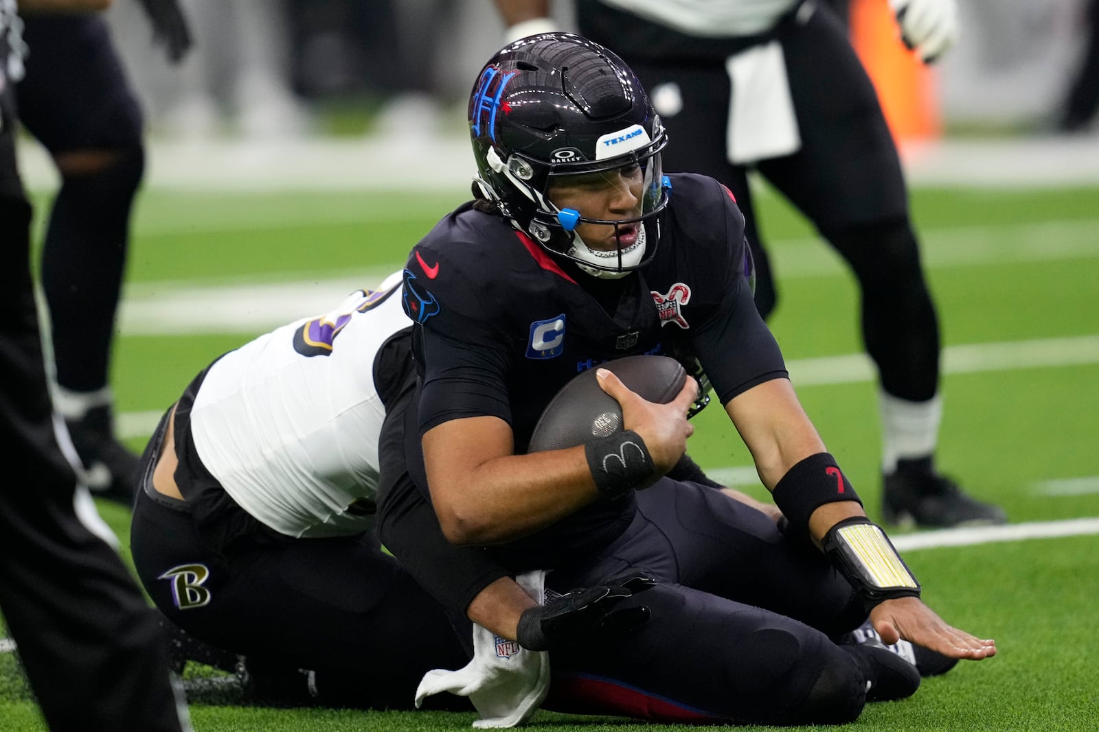 Houston Texans quarterback C.J. Stroud is sacked by Baltimore Ravens linebacker Kyle Van Noy, left, during the first half of an NFL football game, Wednesday, Dec. 25, 2024, in Houston. (AP Photo/David J. Phillip)