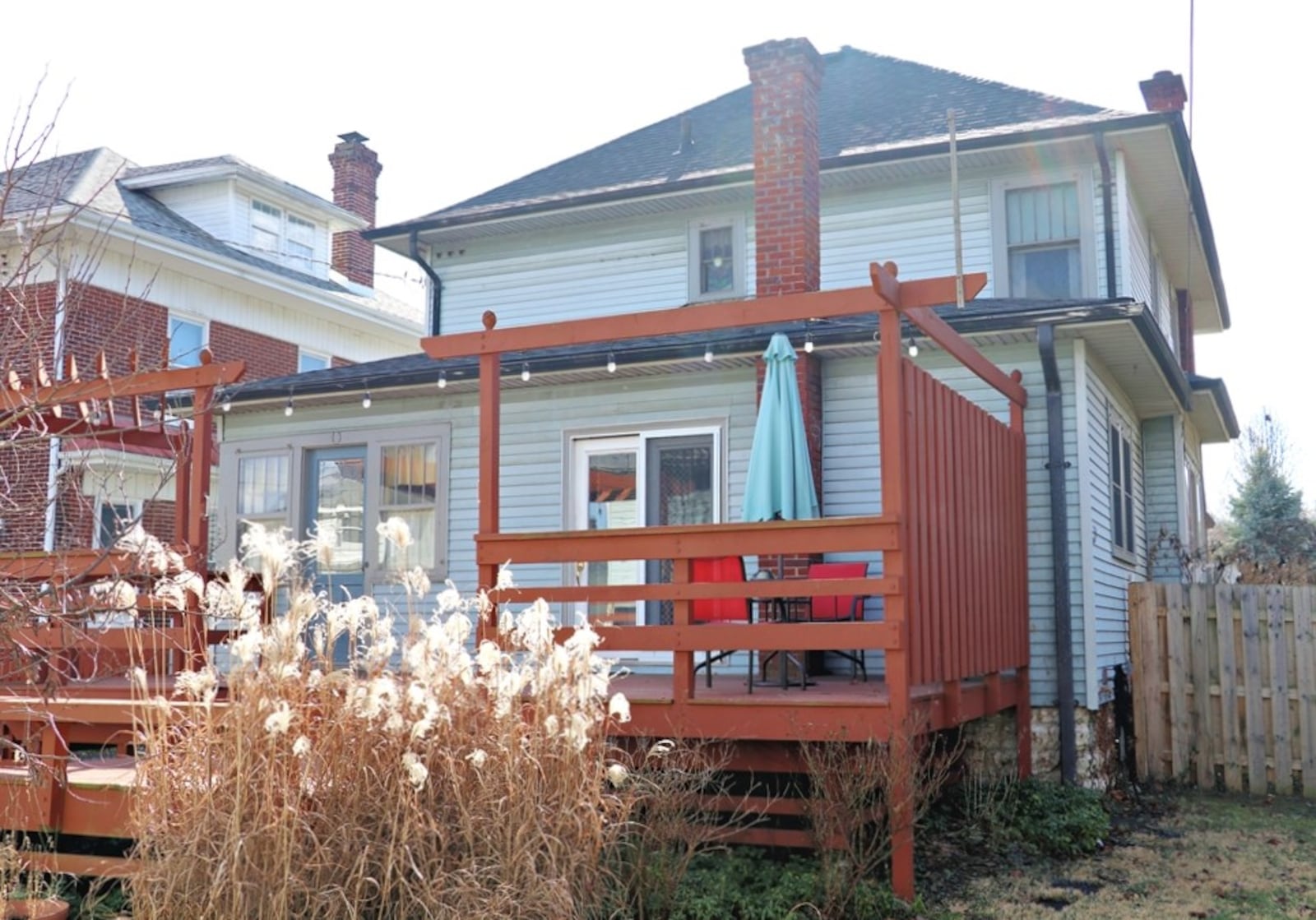 Patio doors open out from the kitchen to the multi-level wooden deck and backyard.