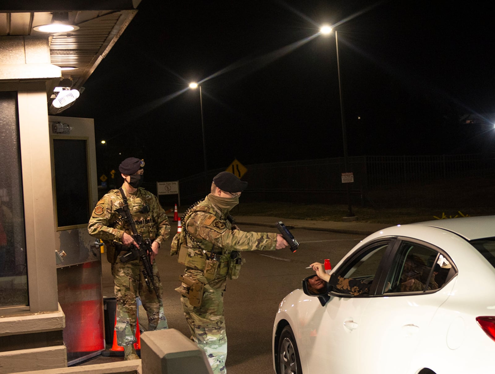 Staff Sgt. Donald Wagner, 88th Security Forces Squadron patrolman, scans the identification of a driver coming through Gate 12A on March 16 alongside Airman 1st Class Ian Hunt. Security Forces are responsible for providing base defense and law enforcement on the installation. U.S. AIR FORCE PHOTO/WESLEY FARNSWORTH