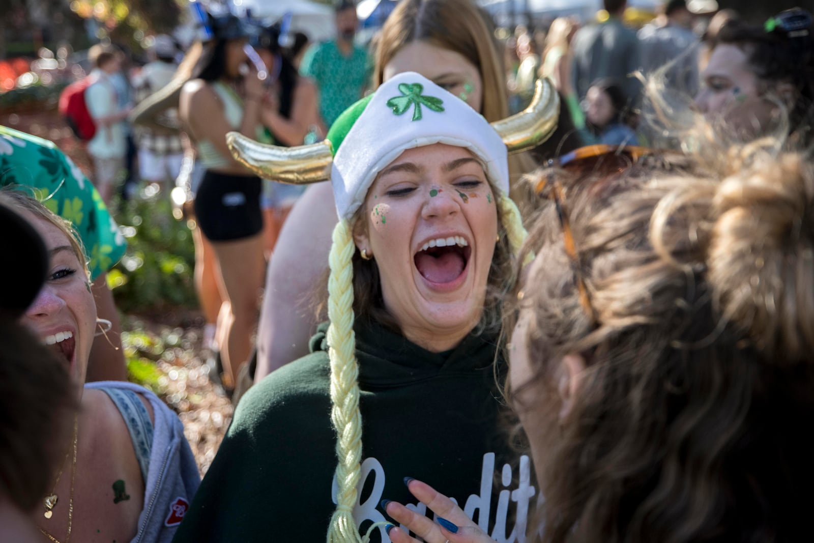 Savannah College of Art and Design student Abby Cooper celebrates with her friends during the St. Patrick's Day parade, Monday, March 17, 2025, in Savannah, Ga. (AP Photo/Stephen B. Morton)