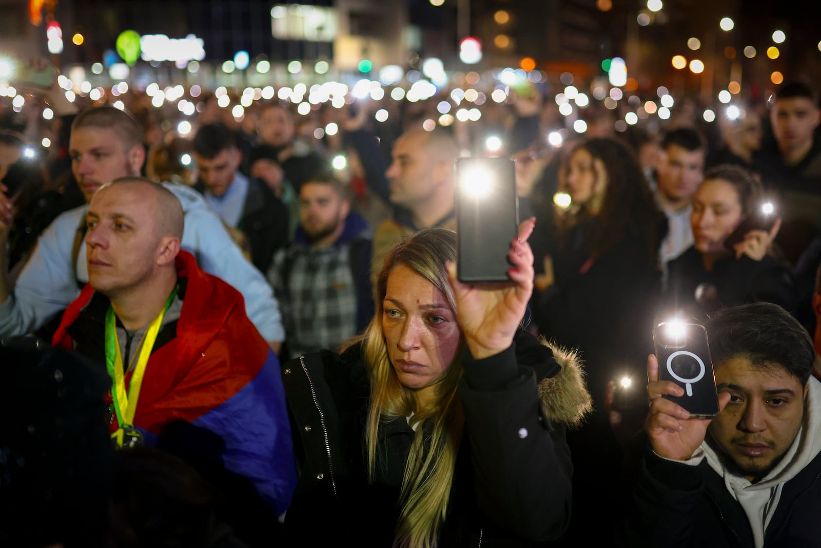 People hold up their mobile phone lights during a protest over the collapse of a concrete canopy that killed 15 people more than two months ago, in Novi Sad, Serbia, Friday, Jan. 31, 2025. (AP Photo/Armin Durgut)