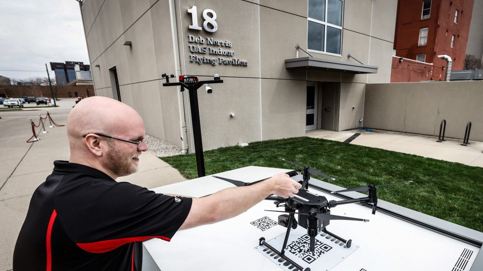 Sinclair College student, Sam Heckel, positions a drone in a docking station that will be manufactured in the Dayton area. The stations will expand and extend the reach of drones. JIM NOELKER/STAFF