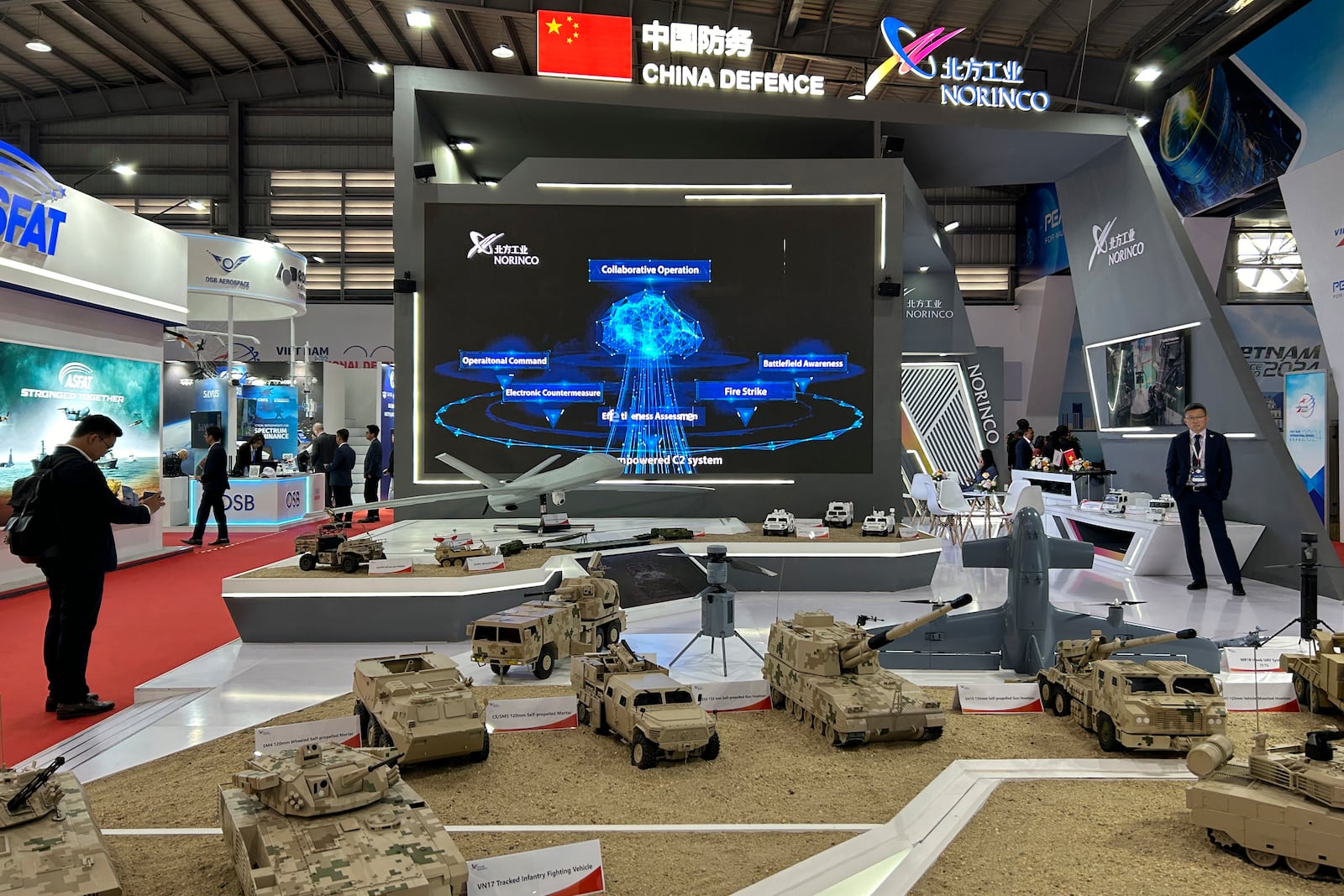 A man takes a photograph of China's NORINCO stall at the Vietnam International Defense Expo held in Hanoi, Vietnam, Thursday, Dec.19, 2024. (AP Photo/Aniruddha Ghosal)