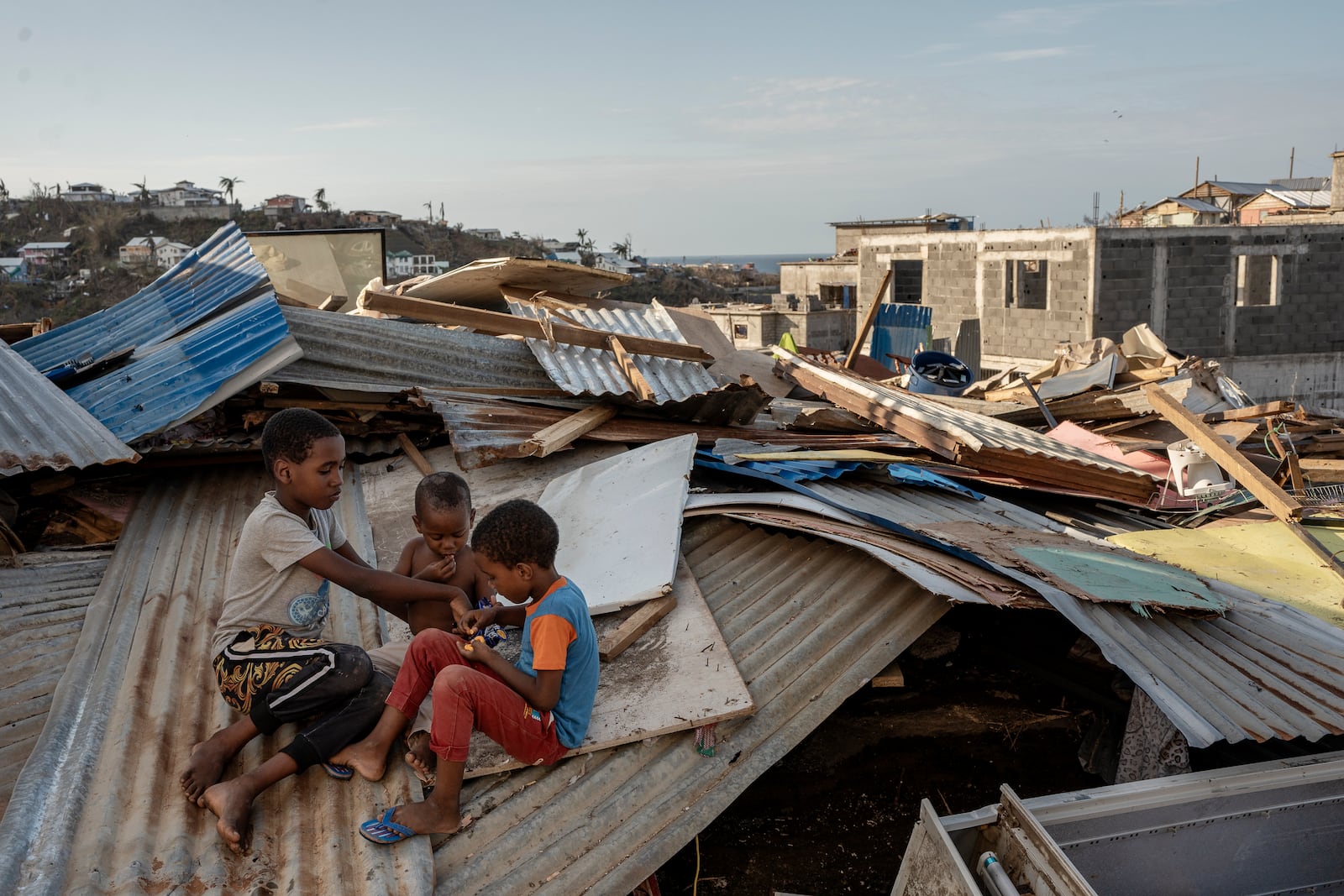 Children play in Majicavo Koropa, Mayotte, Friday, Dec. 20, 2024. (AP Photo/Adrienne Surprenant)