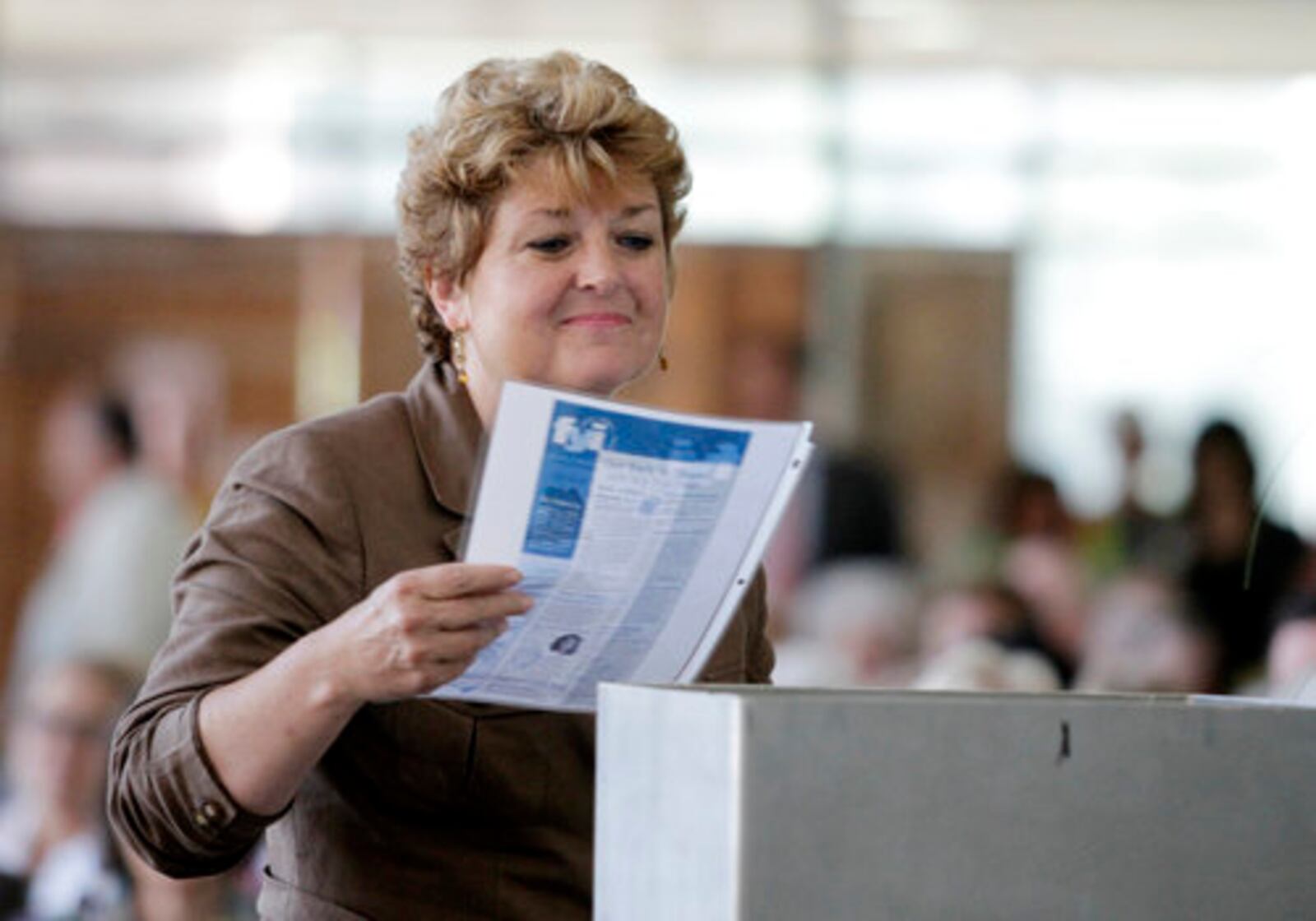 Tina Koumoutsos, executive Diretor for the Neighborhood Housing Partnership of Greater Springfield, contributes to a time capsule during a ceremony at Springfield Regional Medical Center on Wednesday, July 13, 2011.