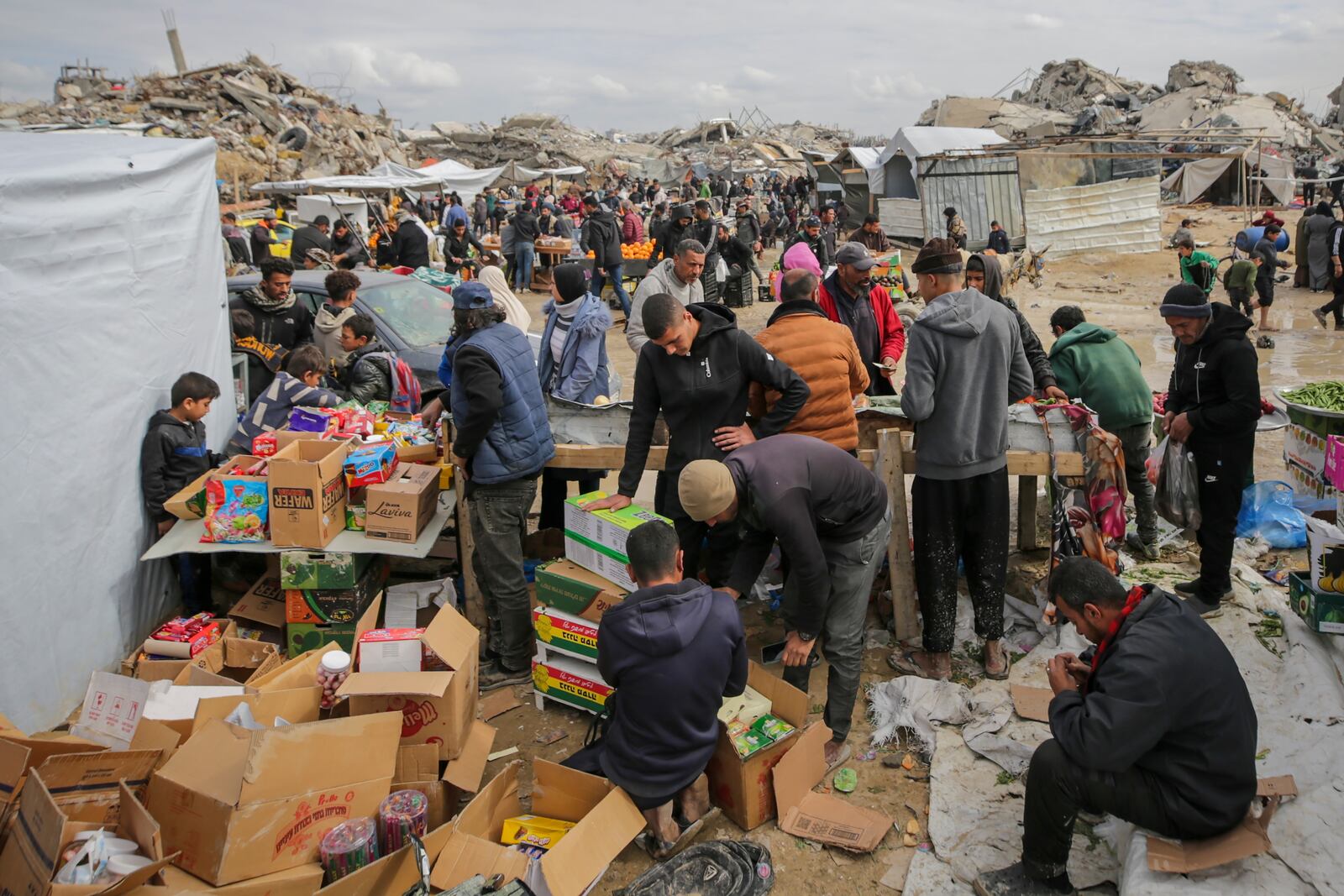 Palestinians purchase goods at a makeshift market set up amid widespread destruction caused by the Israeli military's ground and air offensive in Gaza City's Jabaliya refugee camp, Friday, Feb. 7, 2025. (AP Photo/Jehad Alshrafi)