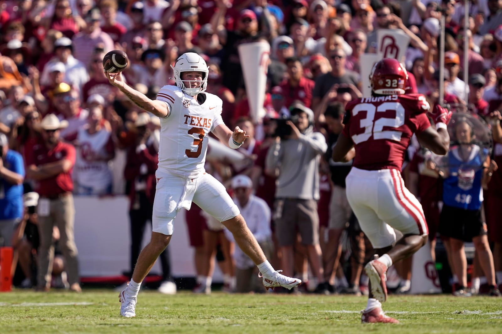 Texas quarterback Quinn Ewers (3) throws a pass under pressure from Oklahoma defensive lineman R Mason Thomas (32) in the first half of an NCAA college football game in Dallas, Saturday, Oct. 12, 2024. (AP Photo/Tony Gutierrez)