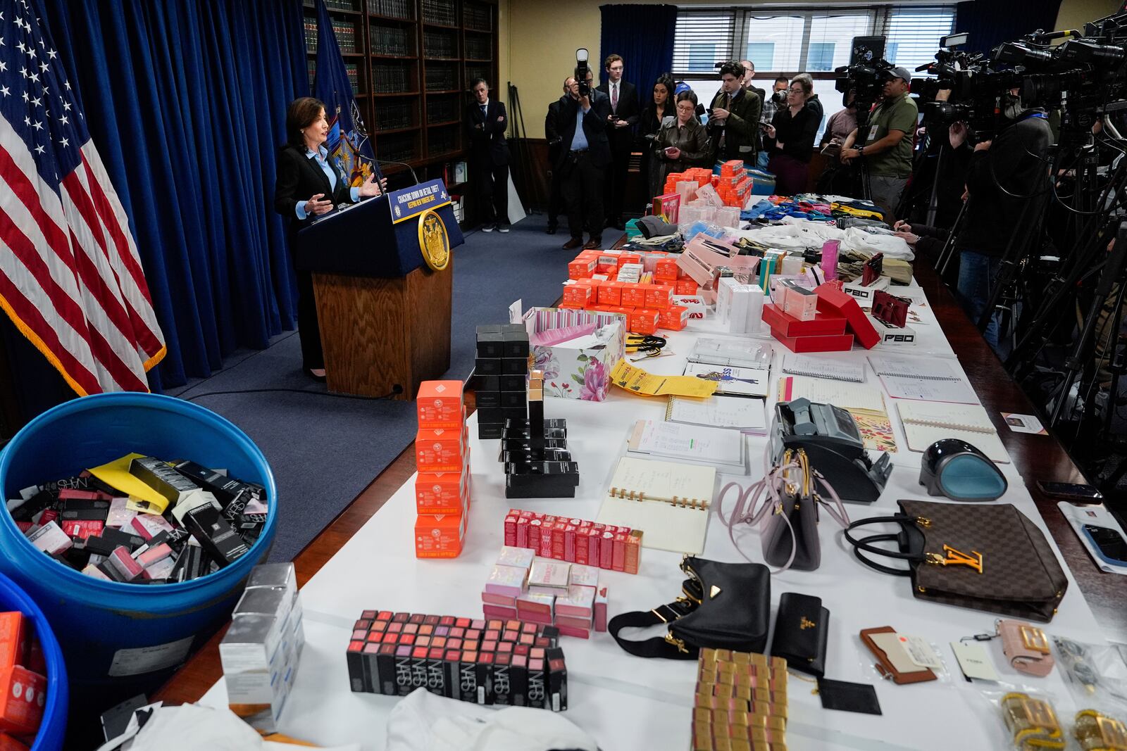 Stolen merchandise is displayed as New York Gov. Kathy Hochul speaks at a news conference on an international stolen merchandise ring, Tuesday, Nov. 26, 2024, in the Queens borough of New York. (AP Photo/Julia Demaree Nikhinson)