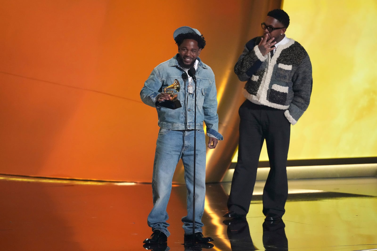 Kendrick Lamar, left, accepts the record of the year award for "Not Like Us during the 67th annual Grammy Awards on Sunday, Feb. 2, 2025, in Los Angeles. Mustard looks on from right. (AP Photo/Chris Pizzello)