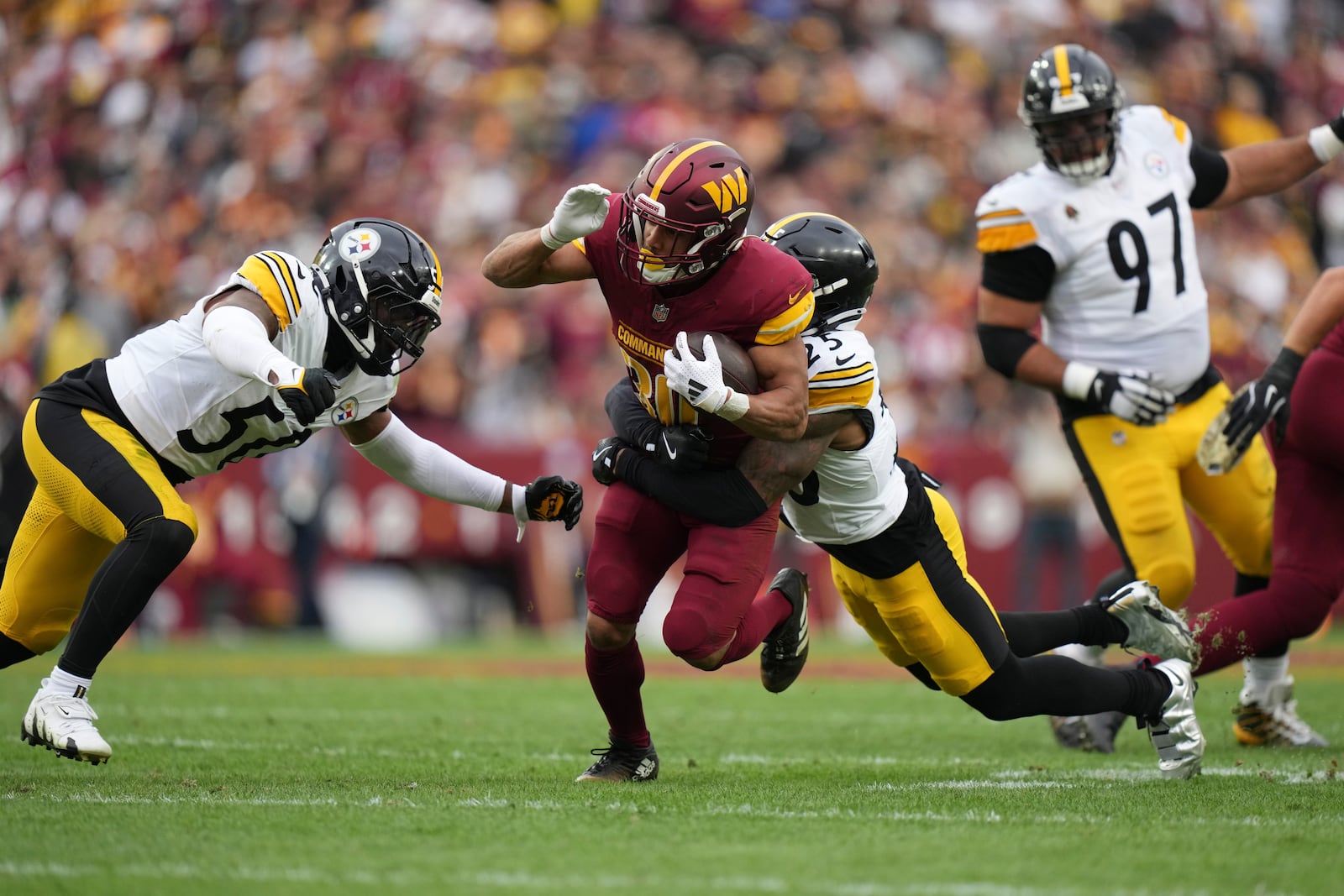 Washington Commanders running back Austin Ekeler (30) is tackled by Pittsburgh Steelers safety DeShon Elliott (25) during the first half of an NFL football game, Sunday, Nov. 10, 2024, in Landover, Md. (AP Photo/Stephanie Scarbrough)