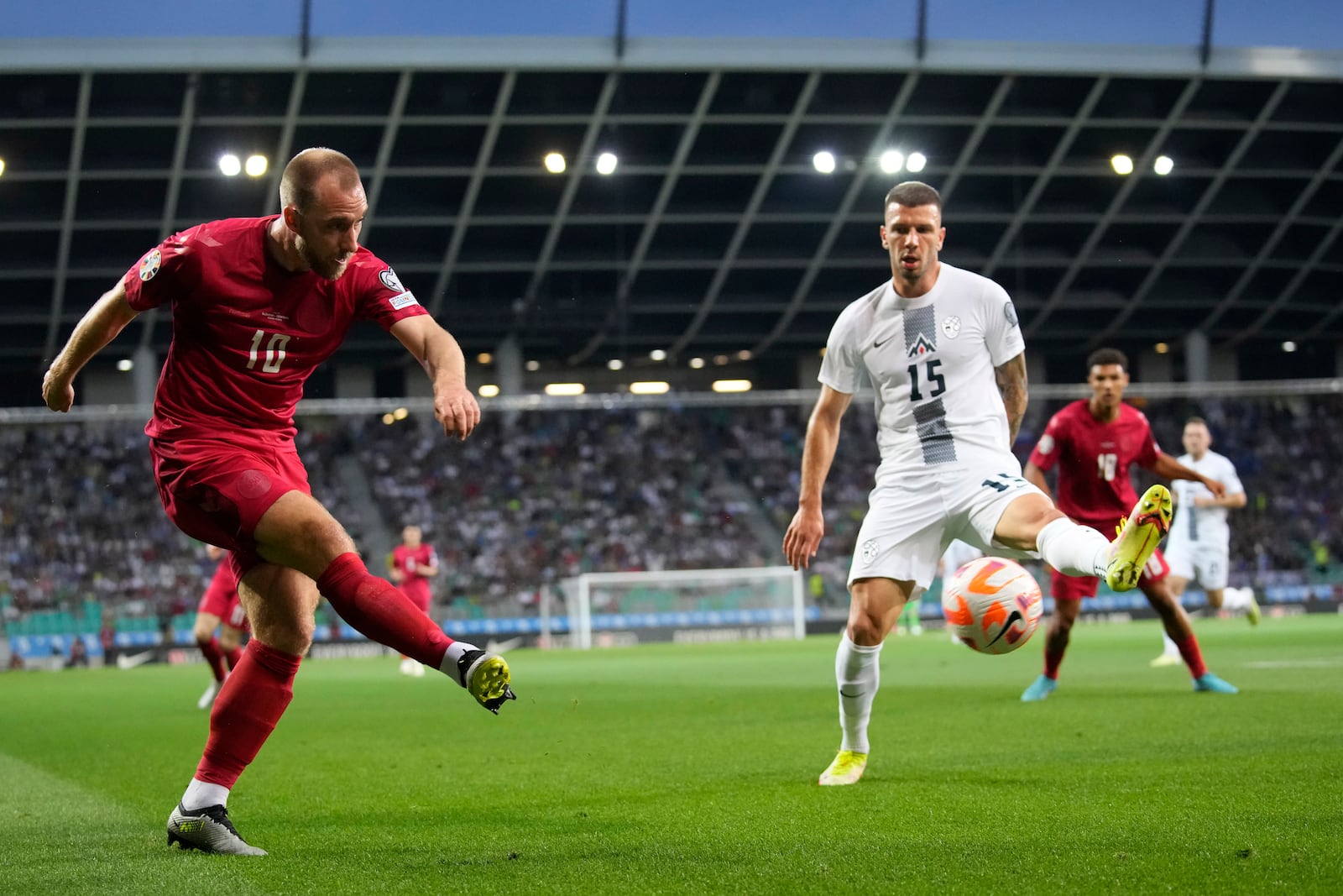 Denmark's Christian Eriksen kicks the ball by Slovenia's Jan Mlakar, right, during the Euro 2024 group H qualifying soccer match between Slovenia and Denmark at Stozice stadium in Ljubljana, Slovenia, Monday, June 19, 2023. (AP Photo/Darko Bandic)