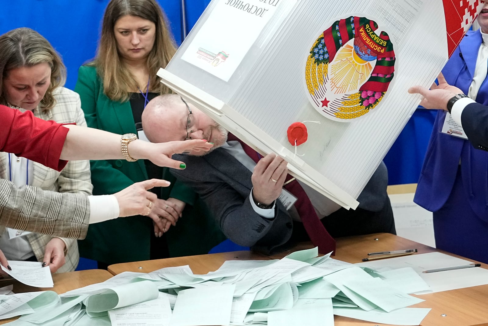 Election commission members prepare to count ballots for the presidential election at a polling station in Minsk, Belarus, Sunday, Jan. 26, 2025. (AP Photo/Pavel Bednyakov)