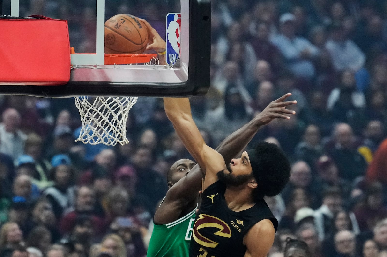 Cleveland Cavaliers center Jarrett Allen, right, dunks over Boston Celtics guard Jaylen Brown, left, in the first half of an NBA basketball game, Tuesday, Feb. 4, 2025, in Cleveland. (AP Photo/Sue Ogrocki)