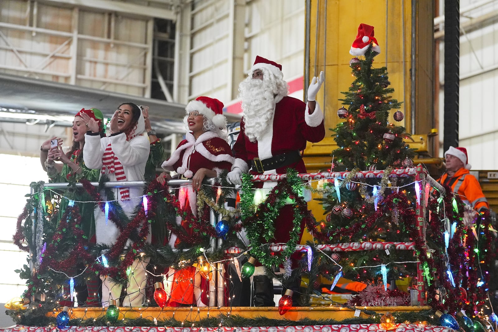 People dressed as Santa Claus and Mrs. Claus greet participants as they disembark from a plane during the United Airlines annual "fantasy flight" to a fictional North Pole at Denver International Airport, Saturday, Dec. 14, 2024, in Denver. (AP Photo/David Zalubowski)