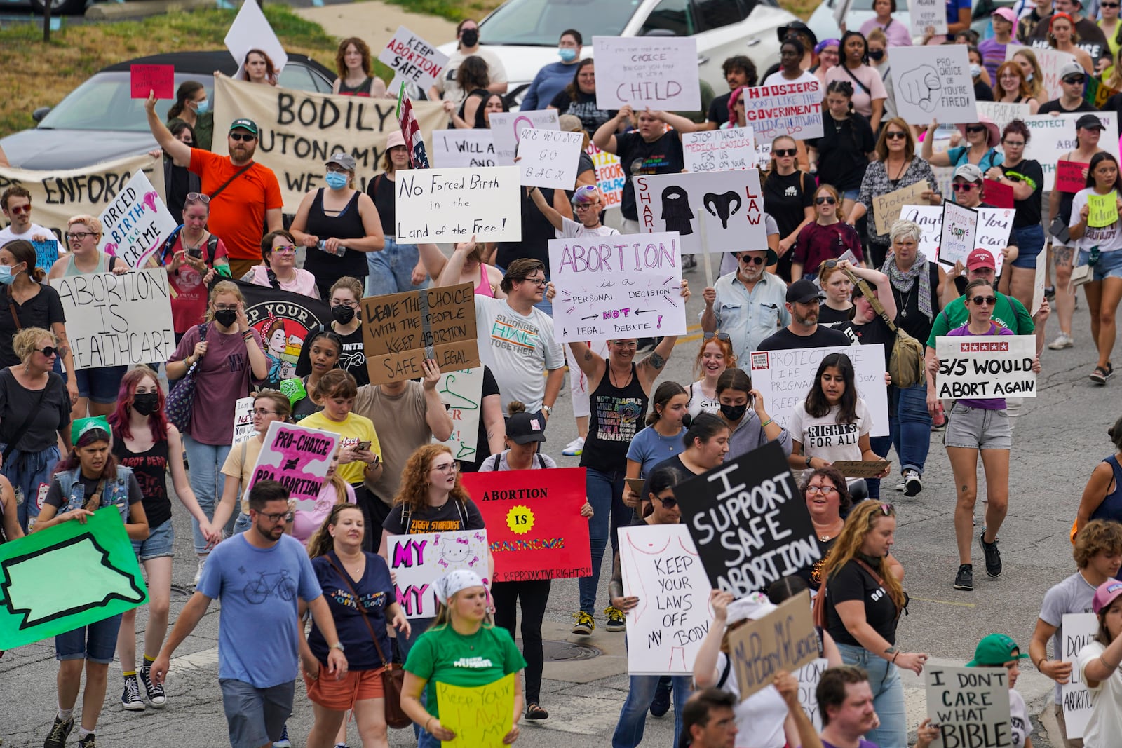 FILE - Abortion-rights protestors march between the Indiana Statehouse and the Indiana State Library where Vice President Kamala Harris was meeting with Indiana legislators to discuss reproductive rights, July 25, 2022, in Indianapolis. (AP Photo/Michael Conroy, File)