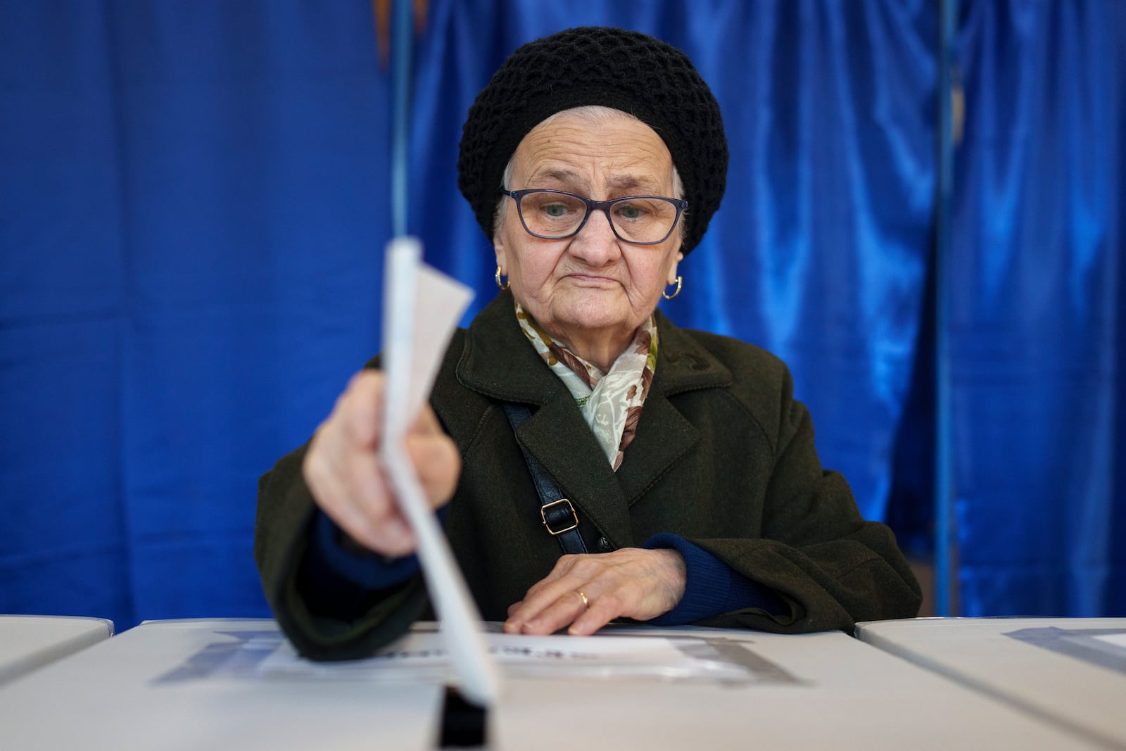 A woman casts her vote in the country's presidential elections, in Bucharest, Romania, Sunday, Nov. 24, 2024. (AP Photo/Vadim Ghirda)