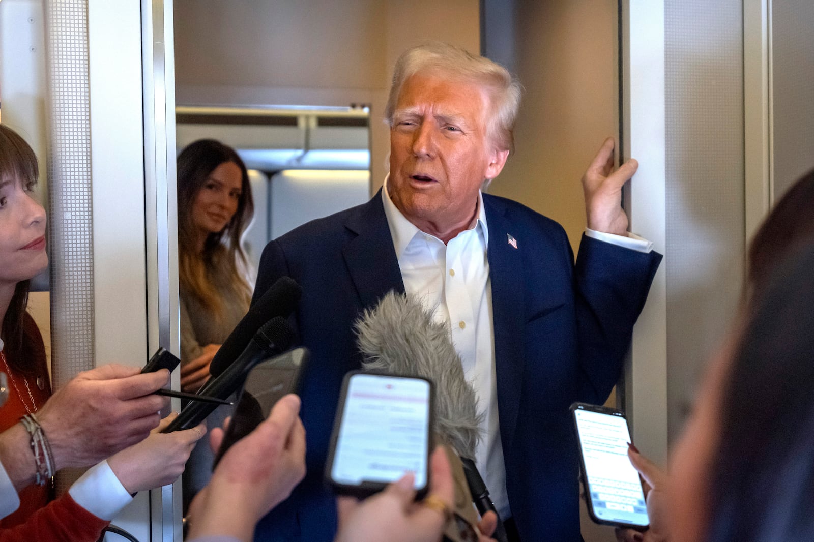 President Donald Trump speaks to reporters aboard Air Force One as he travels from Las Vegas to Miami on Saturday, Jan. 25, 2025. (AP Photo/Mark Schiefelbein)