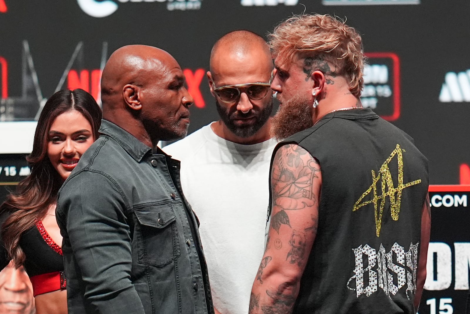 Mike Tyson, front left, and Jake Paul, front right, face off during a news conference ahead of their fight, Wednesday, Nov. 13, 2024, in Irving, Texas. (AP Photo/Julio Cortez)