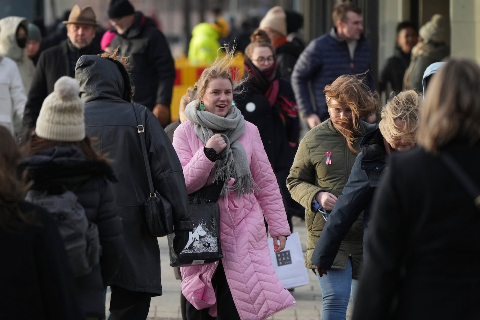 People walk along a street in Helsinki, Finland, Saturday, March 15, 2025. (AP Photo/Sergei Grits)