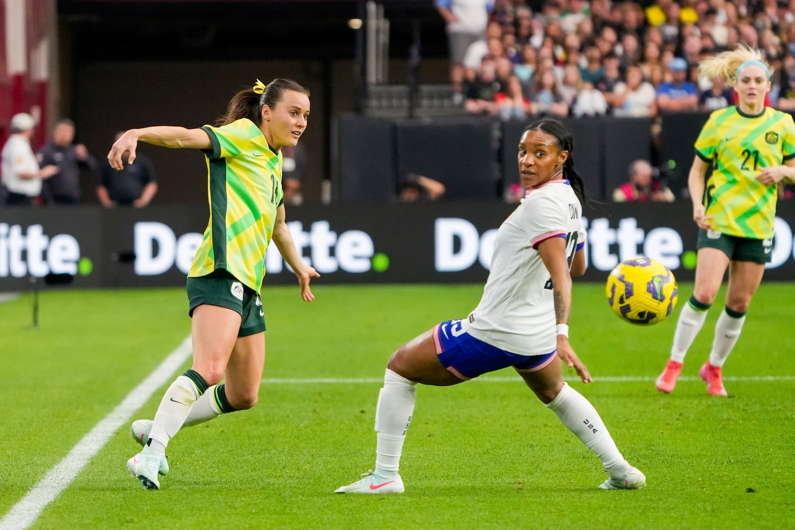 Australia forward Hayley Raso kicks the ball past United States defender Crystal Dunn during the first half of a group stage match in the SheBelieves Cup women's soccer tournament, Sunday, Feb. 23, 2025, in Glendale, Ariz. (AP Photo/Samantha Chow)