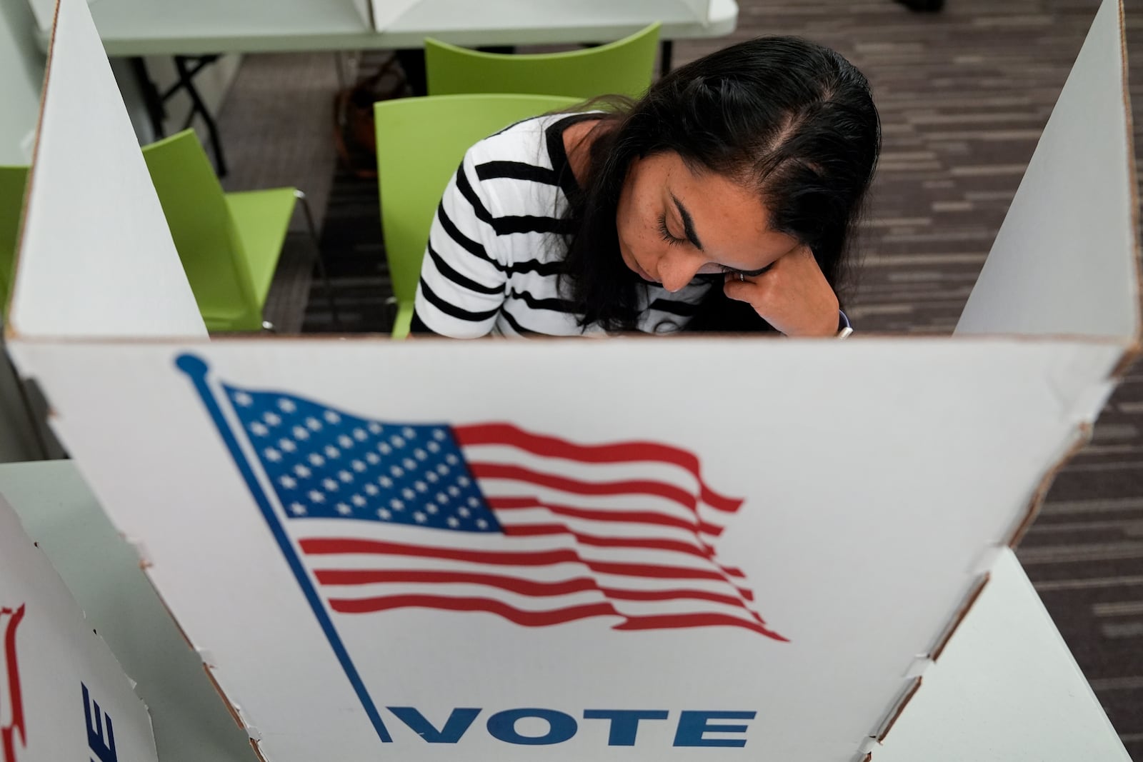 A person marks their ballot at the polling place at Tysons-Pimmit Regional Library in Falls Church, Va., Thursday, Oct. 31, 2024. (AP Photo/Stephanie Scarbrough)