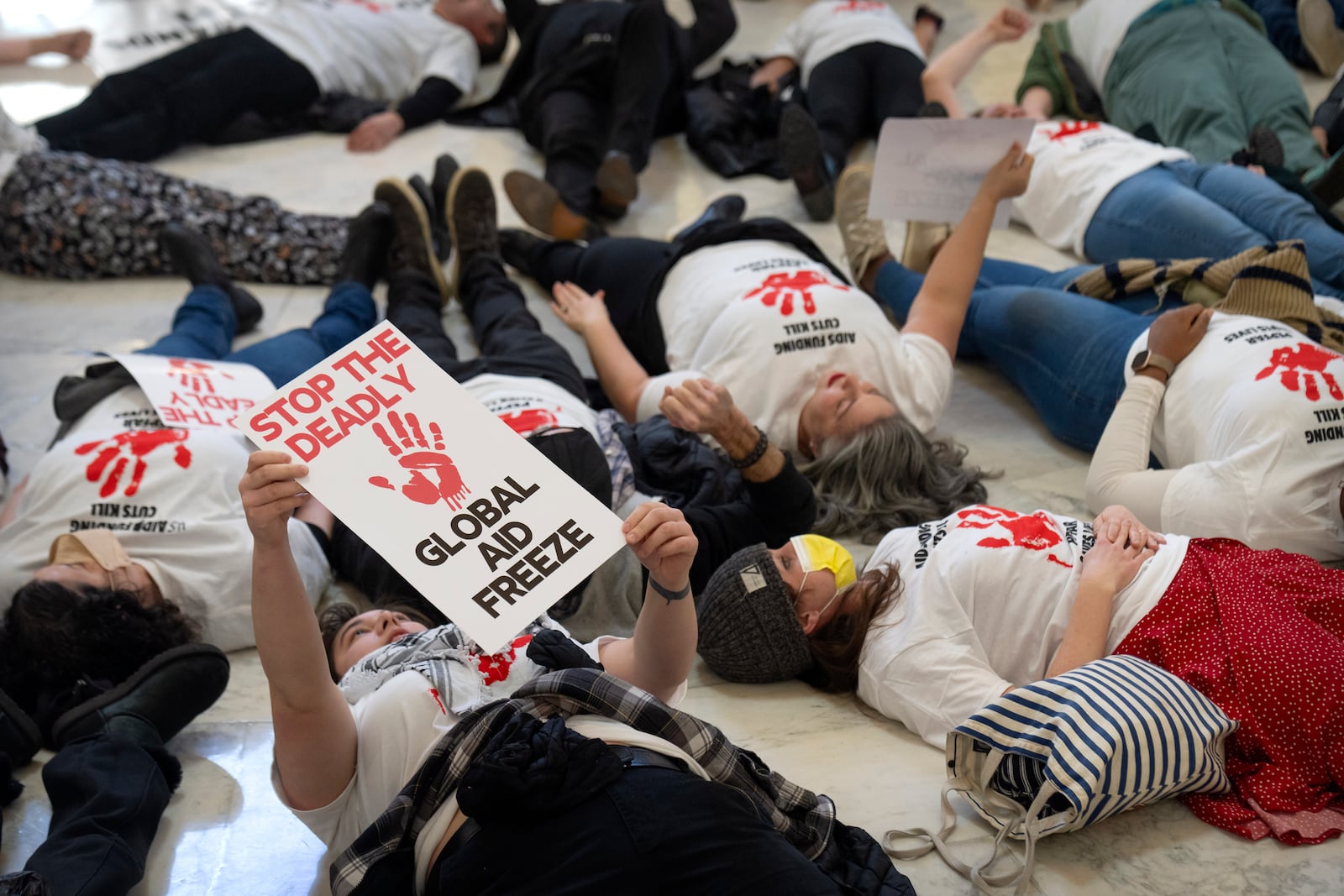 FILE - Demonstrators protest against cuts to American foreign aid spending, including USAID and the PEPFAR program to combat HIV/AIDS, at the Cannon House Office Building on Capitol Hill, Feb. 26, 2025, in Washington. (AP Photo/Mark Schiefelbein, file)