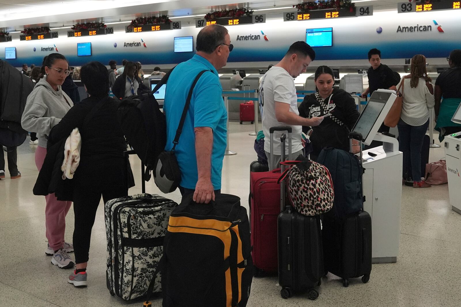 Passengers wait to check-in at Miami International Airport, Tuesday, Nov. 26, 2024, in Miami. (AP Photo/Marta Lavandier)