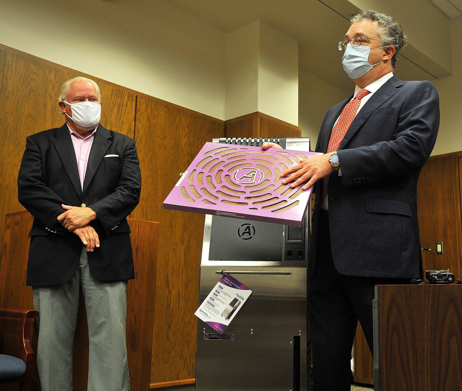 Montgomery County Common Pleas Judge Steven Dankof, left,  and Dr. David Kirschman, president of Aerobiotix, display the Illuvia air re-circulation machine that the courts bought to run during jury trials and hearings. 
Implementing the air re-circulation machines in courtrooms is one of many precautions the common pleas court has taken to keep jurors, defendants, lawyers and court staff safe during the coronavirus pandemic. MARSHALL GORBY\STAFF