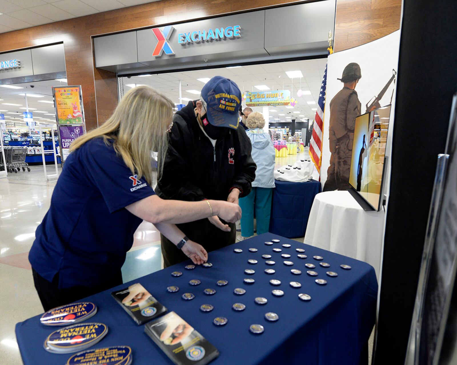 Sandra Church, acting store manager at the Base Exchange, presents buttons to Vietnam War veteran Paul Swisshelm at Wright-Patterson Air Force Base on March 29. As part of National Vietnam War Veterans Day, Exchange managers presented Vietnam veterans with lapel pins and buttons to recognize, thank and honor those who served as they entered the store. U.S. AIR FORCE PHOTO/TY GREENLEES