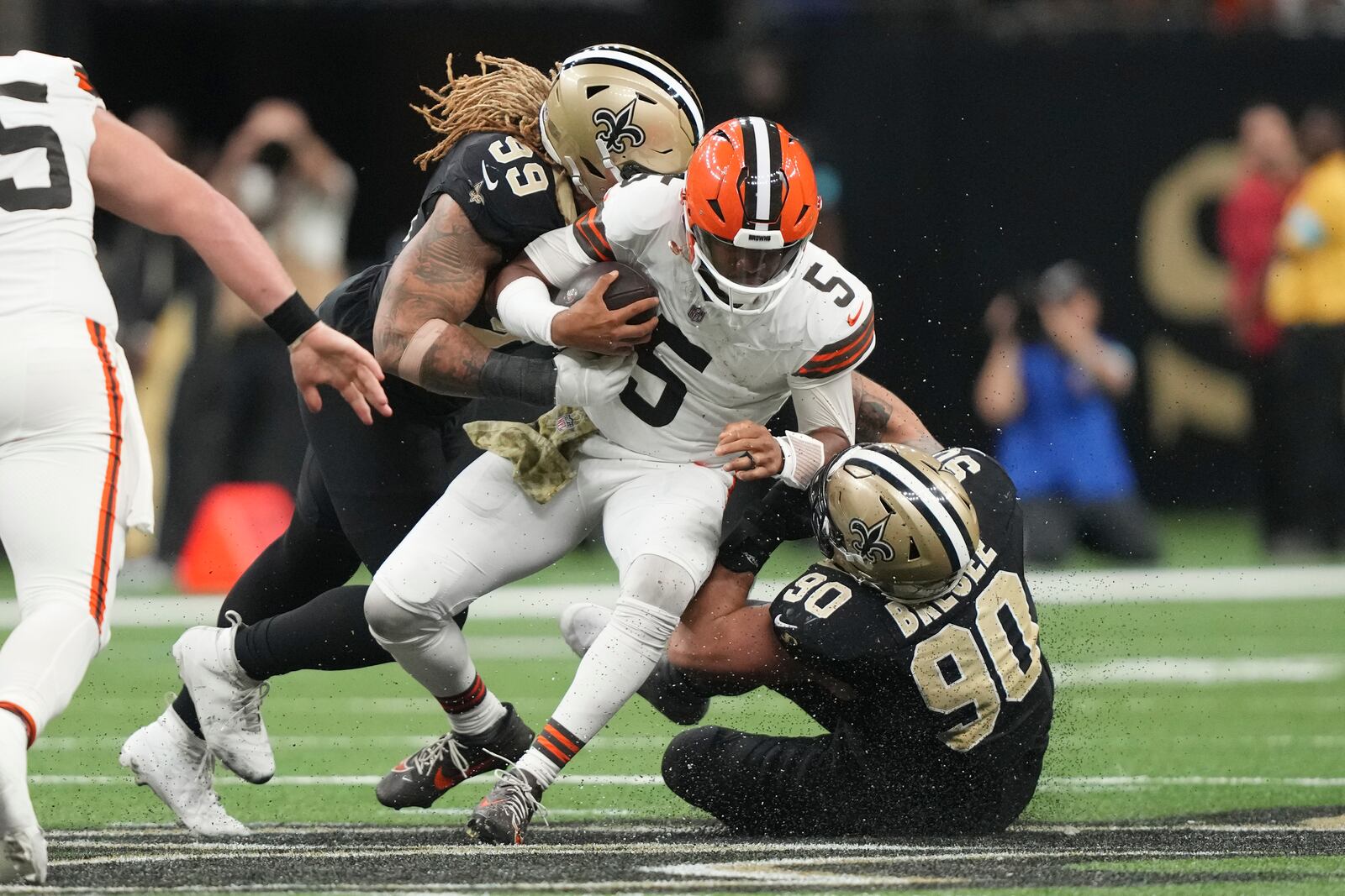 Cleveland Browns quarterback Jameis Winston (5) is tackled by New Orleans Saints defensive end Chase Young (99) and defensive tackle Bryan Bresee after a short gain in the second half of an NFL football game in New Orleans, Sunday, Nov. 17, 2024. (AP Photo/Gerald Herbert)