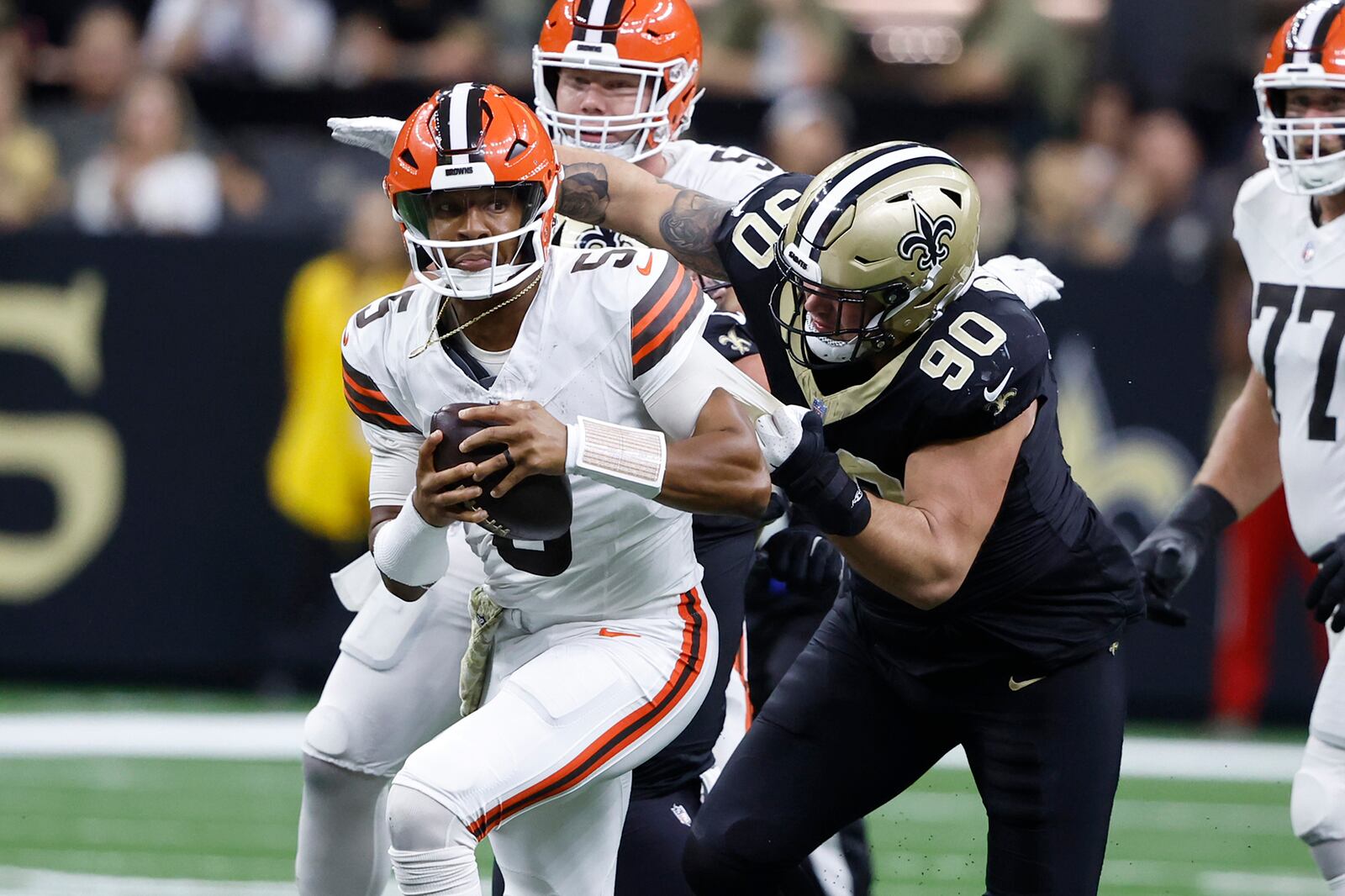 Cleveland Browns quarterback Jameis Winston (5) is tackled by New Orleans Saints defensive tackle Bryan Bresee (90) after a short gain in the second half of an NFL football game in New Orleans, Sunday, Nov. 17, 2024. (AP Photo/Butch Dill)