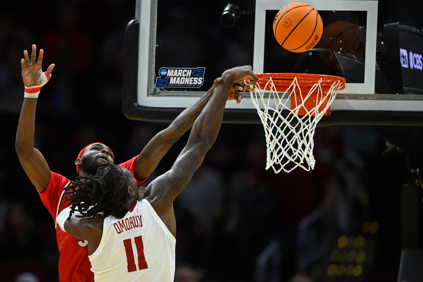 Robert Morris guard Amarion Dickerson, back, defends a shot by Alabama center Clifford Omoruyi (11) in the first half in the first round of the NCAA college basketball tournament, Friday, March 21, 2025, in Cleveland. (AP Photo/David Richard)