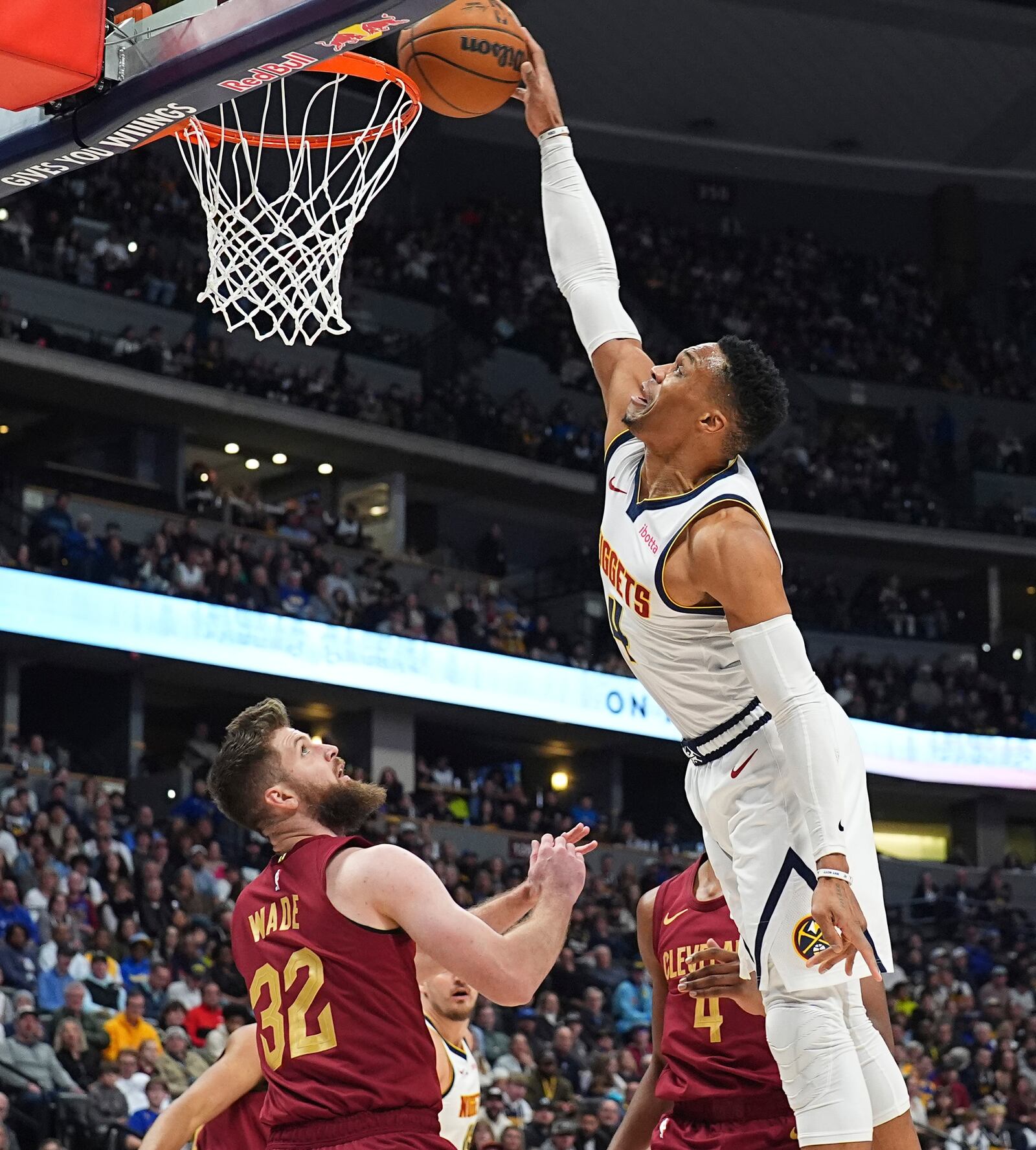 Denver Nuggets guard Russell Westbrook, right, tries to dunk the ball for a basket over Cleveland Cavaliers forward Dean Wade in the first half of an NBA basketball game Friday, Dec. 27, 2024, in Denver. (AP Photo/David Zalubowski)