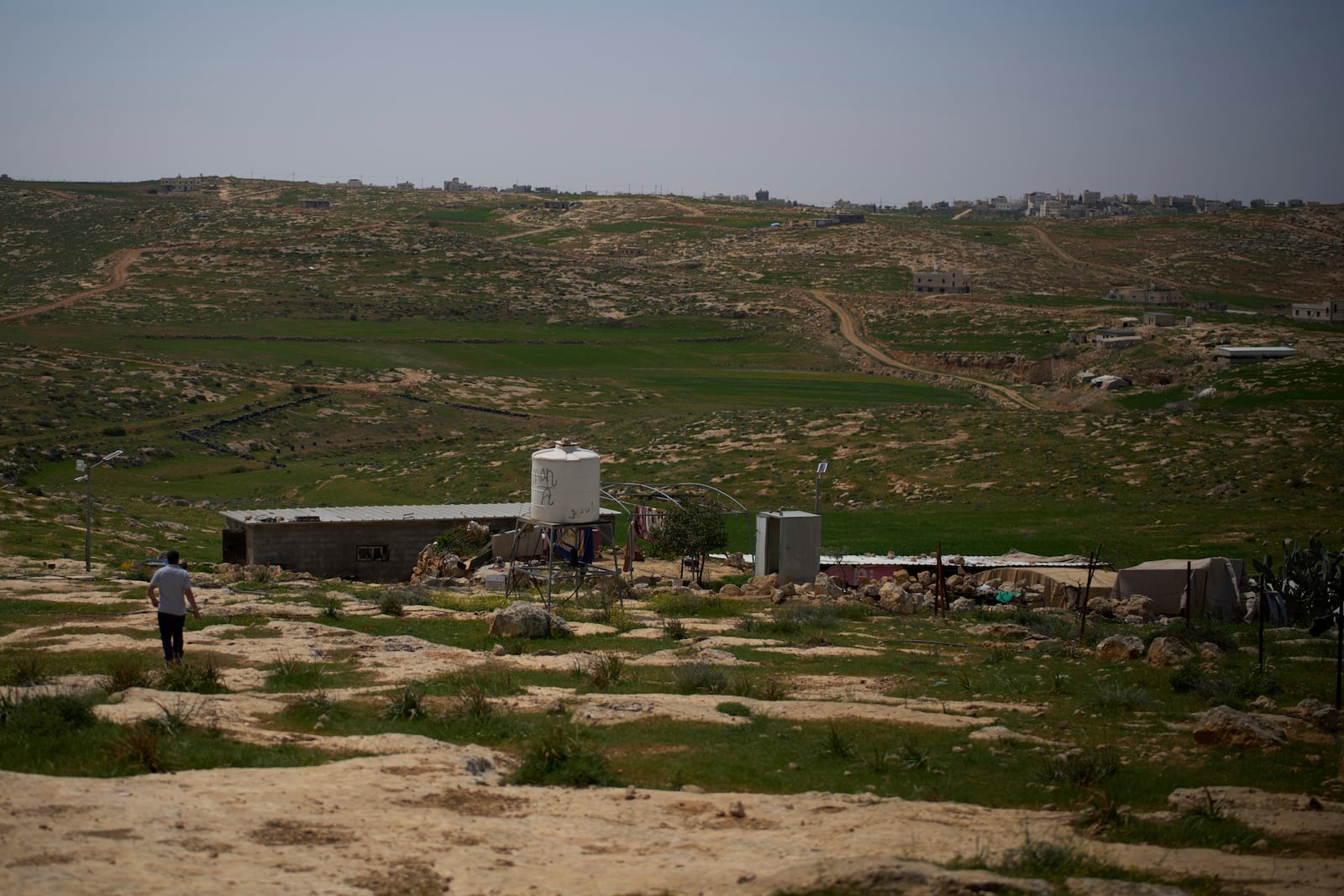 A man walks near the house of Hamdan Ballal, co-director of the Oscar winner documentary "No Other Land", who was attacked by Jewish settlers before being detained by the Israeli army, in the village of Susiya in Masafer Yatta, south Hebron hills Tuesday, March 25, 2025. (AP Photo/Leo Correa)