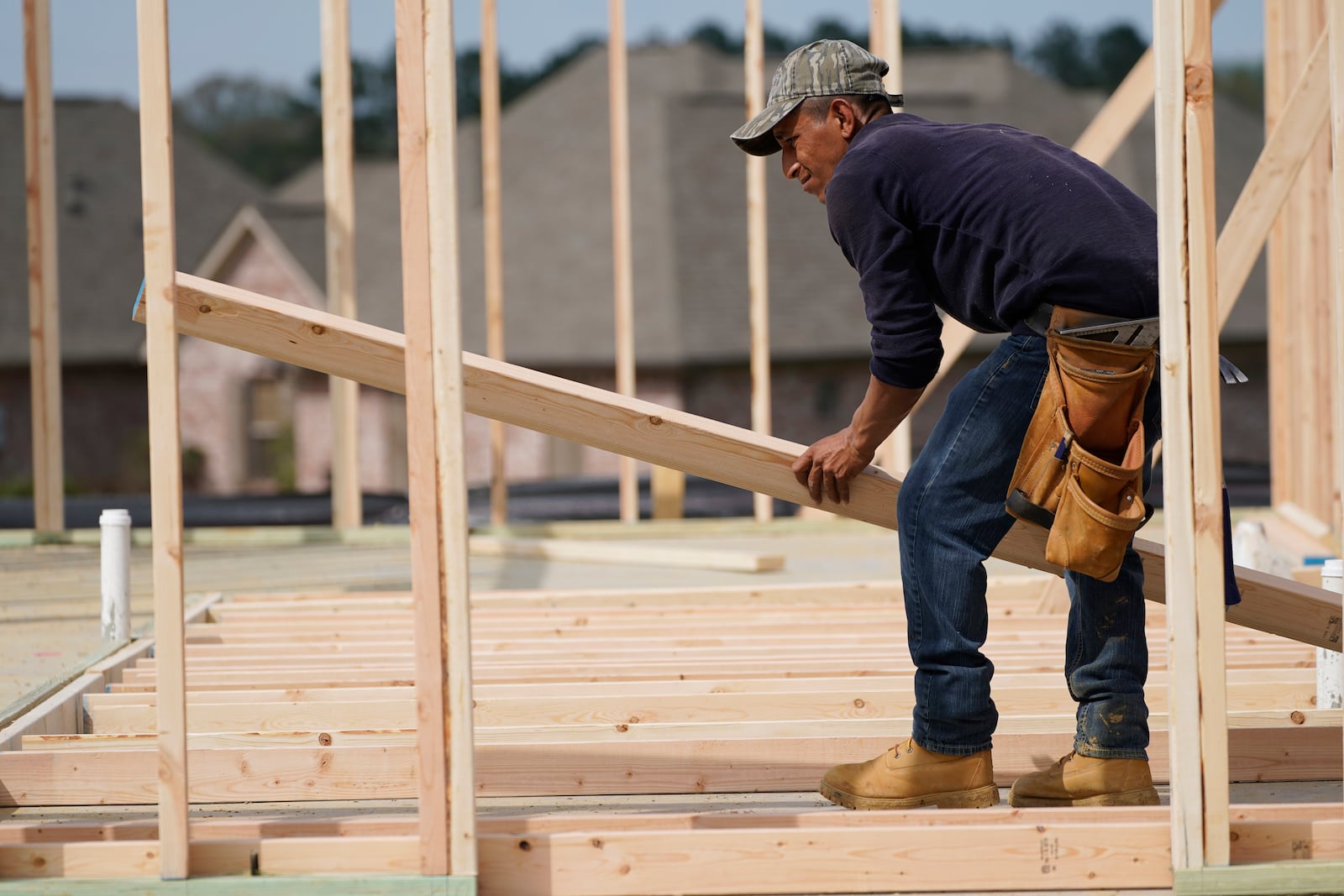 FILE - A carpenter aligns a beam for a wall frame at a new house site in Madison County, Miss., Tuesday, March 16, 2021. (AP Photo/Rogelio V. Solis, File)