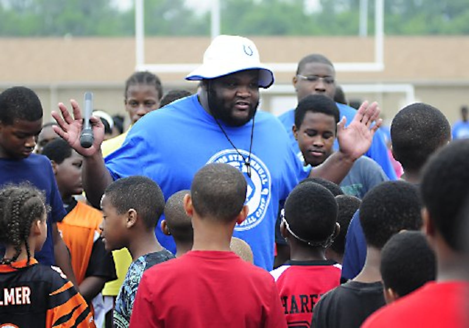 Brandon McKinney defensive lineman for the Indianapolis Colts with children at the BJ 91 Kids 6th Annual Football Camp held Saturday June 29, 2013 at Trotwood-Madison High School. / CHARLES CAPERTON PHOTO