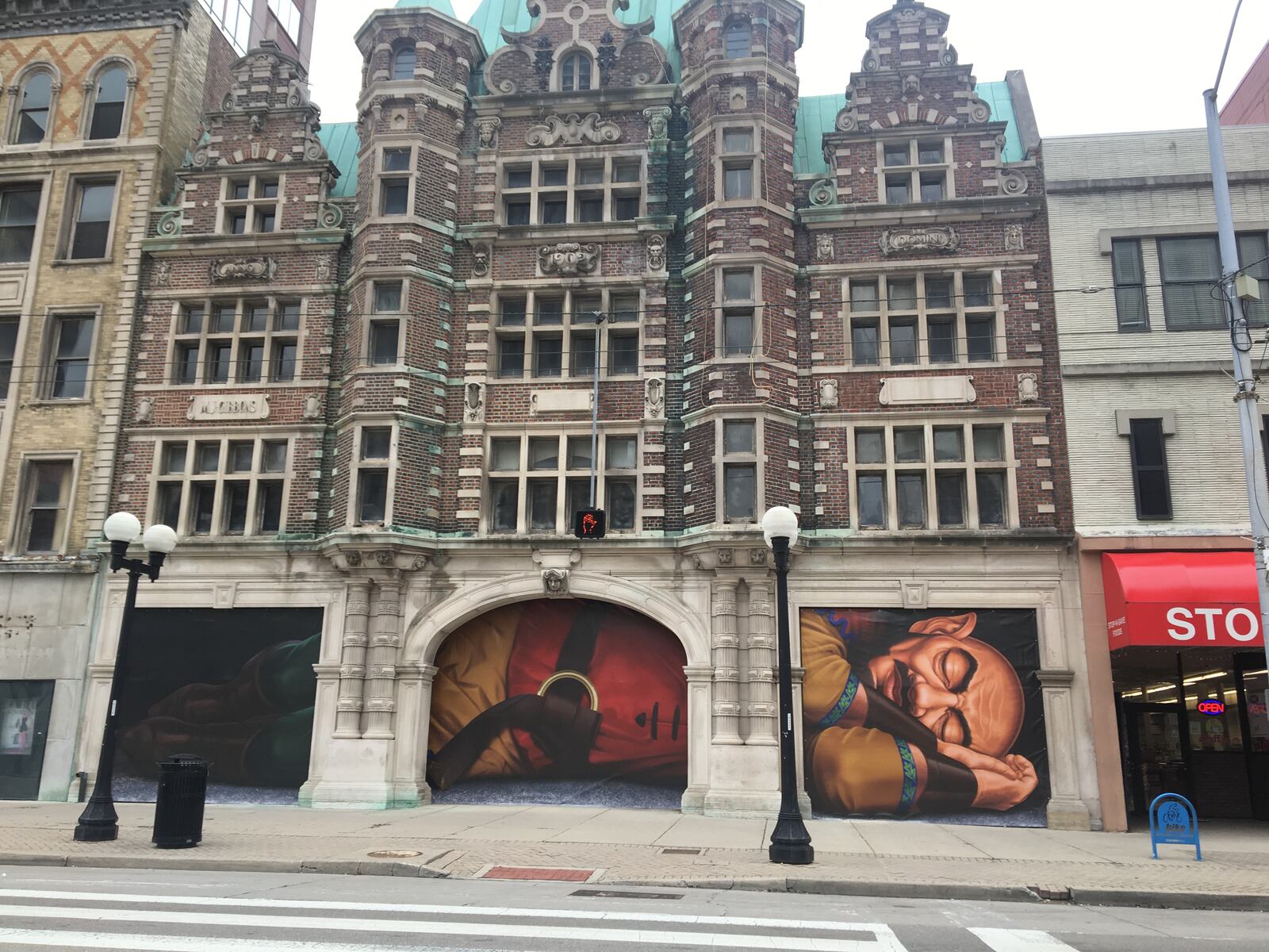 Vinyl posters depicting a sleeping giant are covering the north entrance of the Dayton Arcade. CORNELIUS FROLIK/STAFF