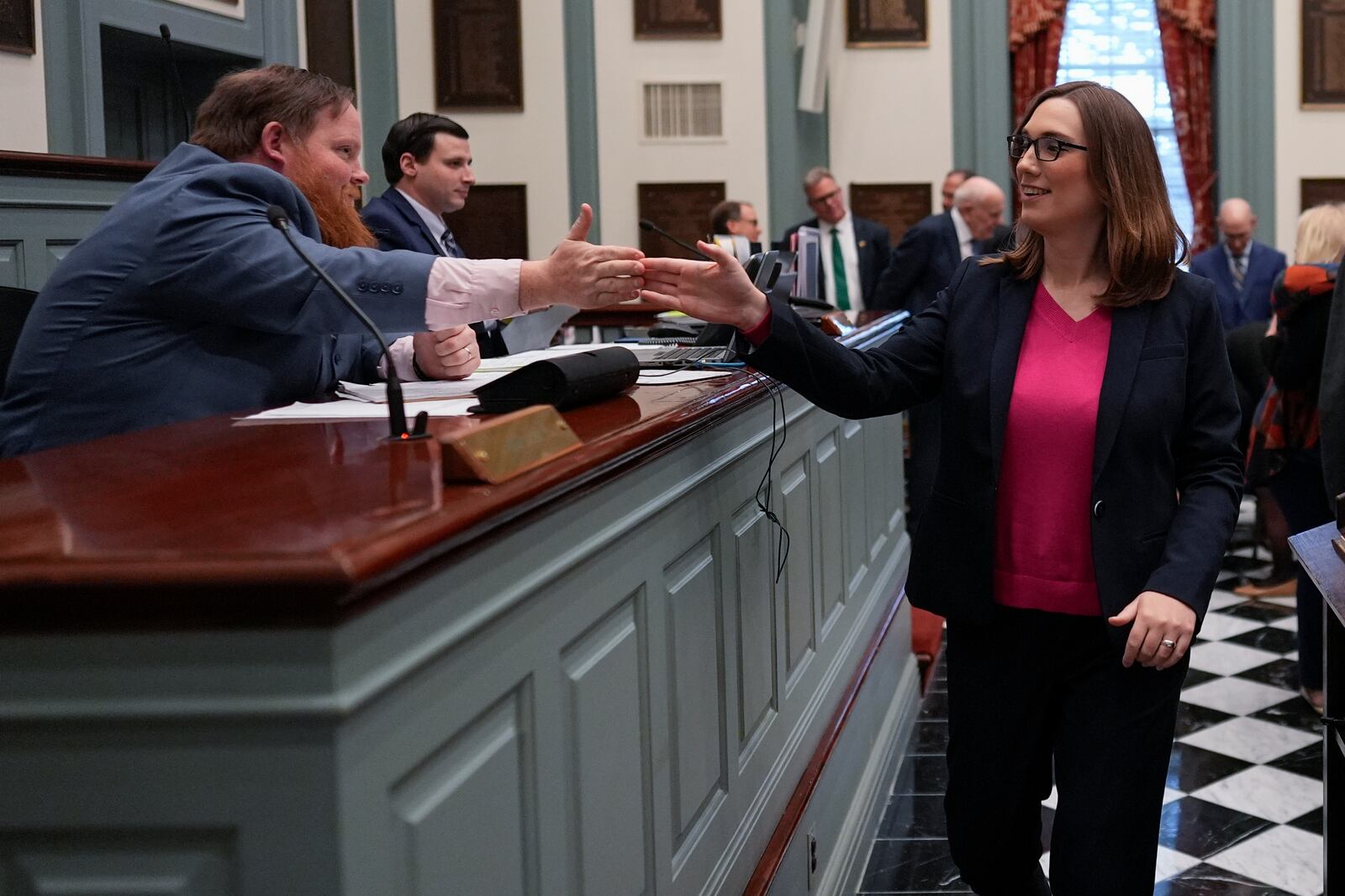 U.S.-Rep.-elect Sarah McBride, D-Del., celebrates with Assistant Secretary of the Senate Daniel Yngstrom, left, on the Senate floor during a special session, her last day as a Delaware state senator, at the Delaware Legislative Hall in Dover, Del., Monday, Dec. 16, 2024. (AP Photo/Carolyn Kaster)