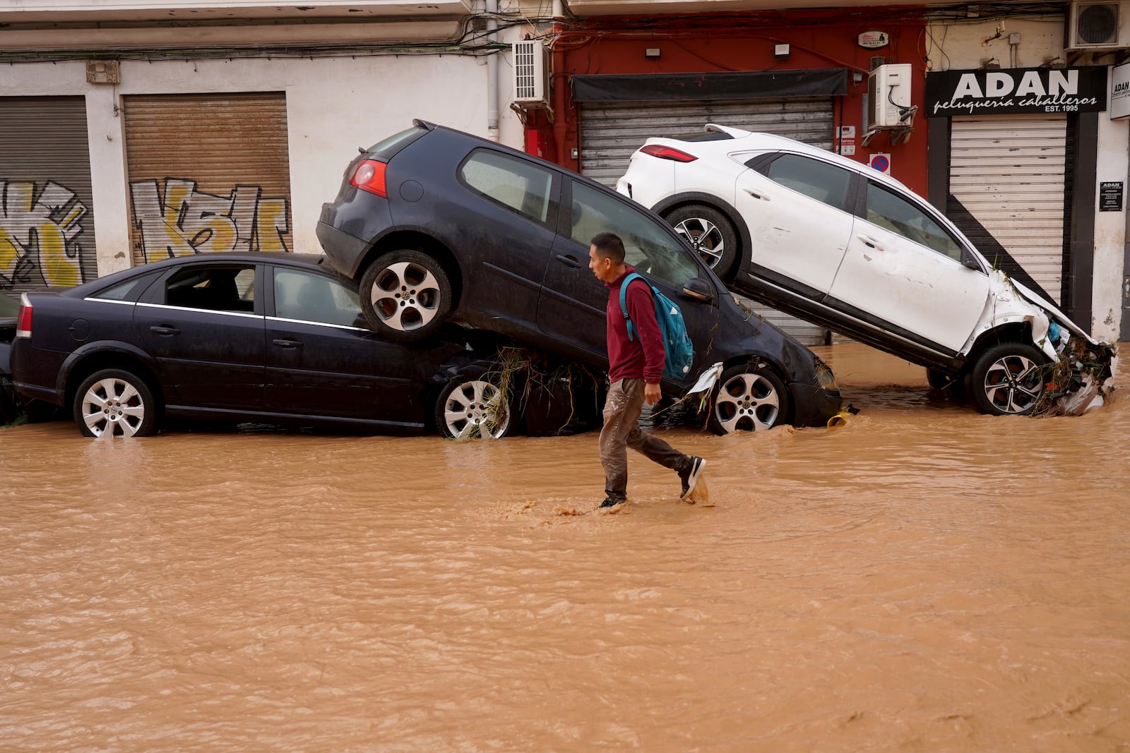 A man walks through flooded streets in Valencia, Spain, Wednesday, Oct. 30, 2024. (AP Photo/Alberto Saiz)