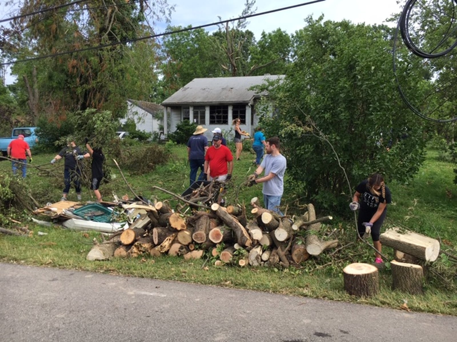 Volunteers gathered tree limbs Saturday in a storm-damaged area on Graham Drive in Beavercreek, just west of Grange Hall Road. THOMAS GNAU/STAFF