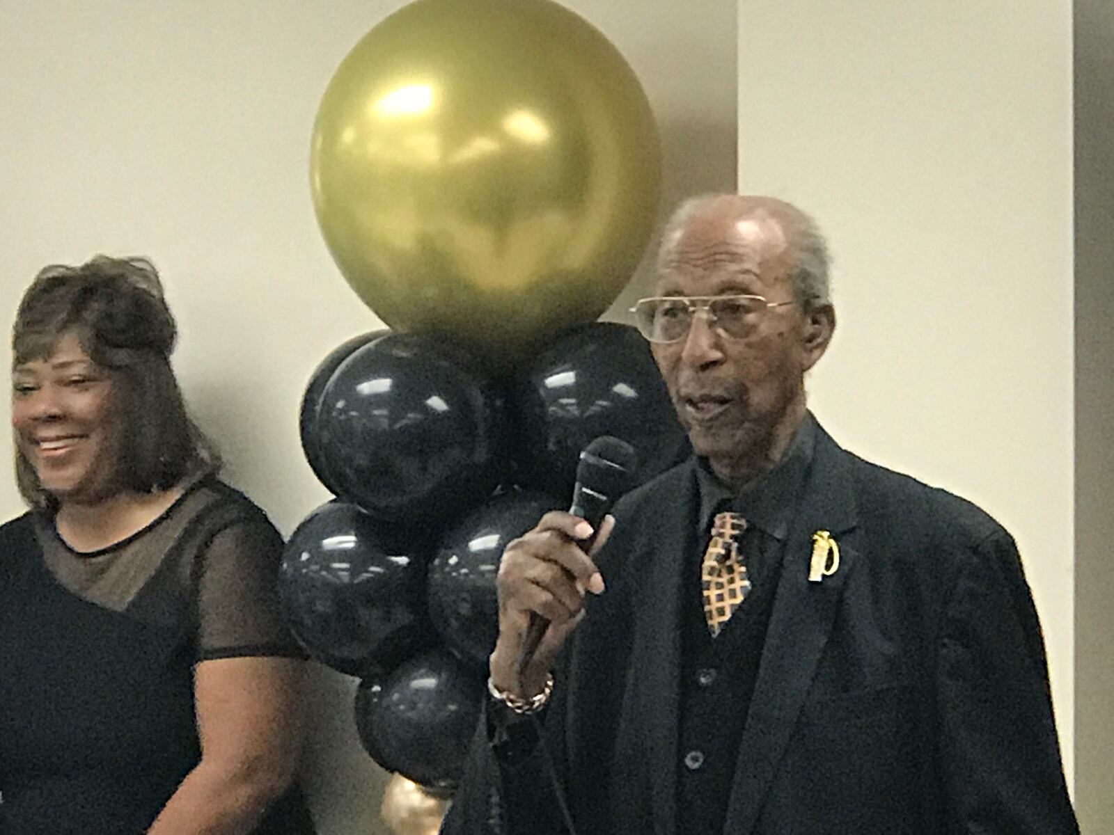 Marion Miller, a West Dayton World War II veteran who turned 100, on Wednesday speaks to the crowd at his birthday party Saturday at St, Margaret’s Episcopal Church on Free Pike. His daughter, Lisa Tooson, who lives in Springfield, listens behind him. Soon after he was dancing to Luther Vandross as the crowd cheered his moves.
Tom Archdeacon/CONTRIBUTED