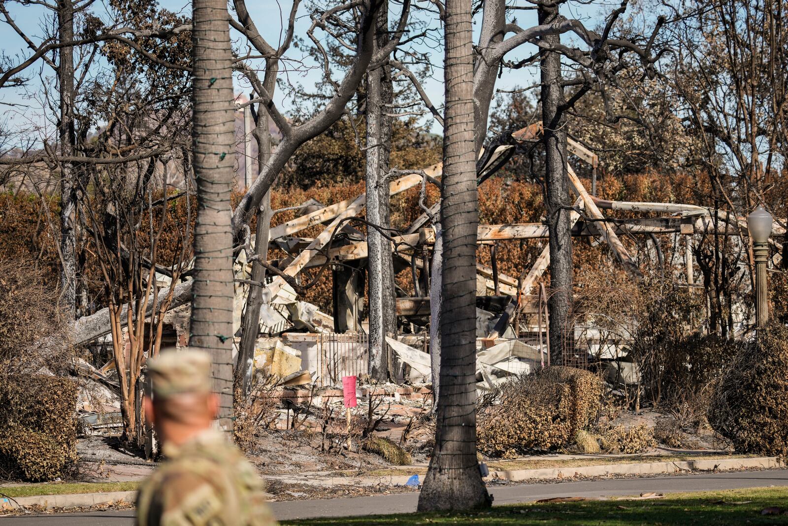 A members of the National Guard stands at a checkpoint as President Donald Trump is set to tour the Palisades Fire zone damage in the Pacific Palisades neighborhood of Los Angeles, Friday, Jan. 24, 2025. (AP Photo/Damian Dovarganes)