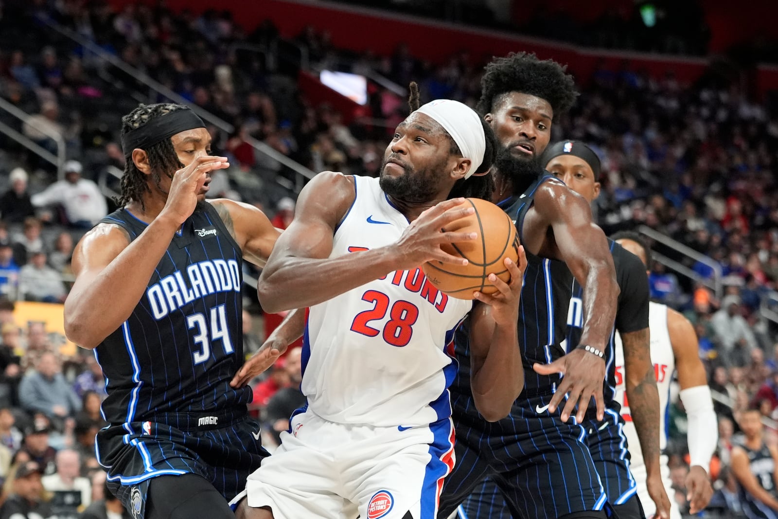 Detroit Pistons center Isaiah Stewart (28) is defended by Orlando Magic center Wendell Carter Jr. (34) during the first half of an NBA basketball game, Wednesday, Jan. 1, 2025, in Detroit. (AP Photo/Carlos Osorio)