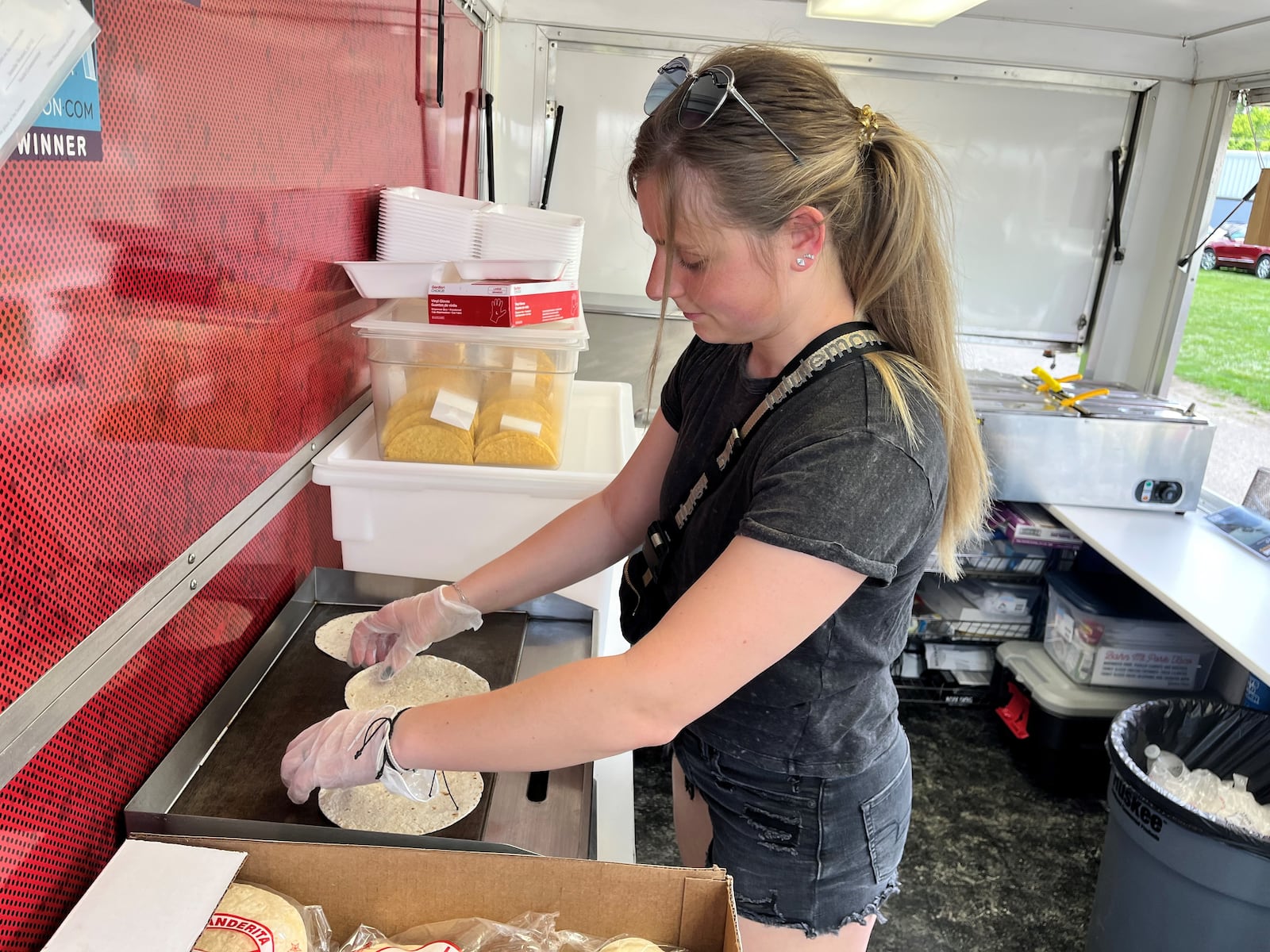 Reporter Natalie Jones warms up tortillas on the What The Taco?! food truck.