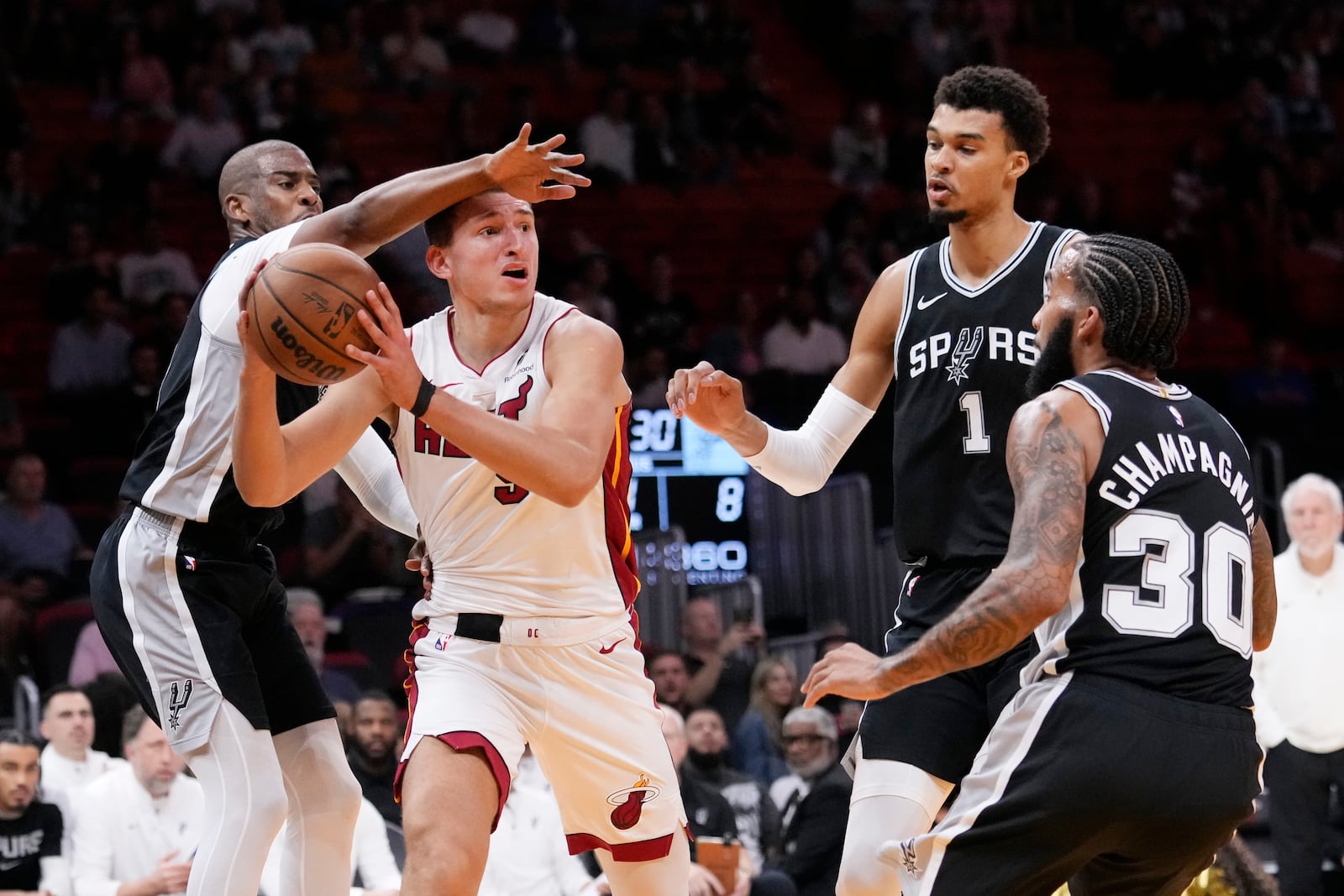 Miami Heat forward Nikola Jovic, second from left, looks for an opening past San Antonio Spurs guard Chris Paul, left, forwards Victor Wembanyama (1) and Julian Champagnie (30) during the first half of an NBA preseason basketball game, Tuesday, Oct. 15, 2024, in Miami. (AP Photo/Wilfredo Lee)