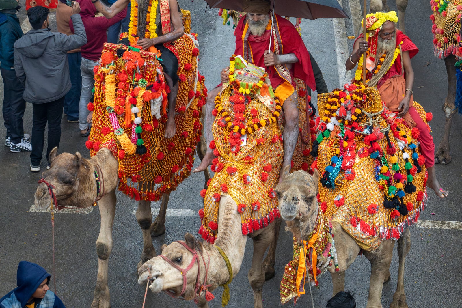 Hindu holy men ride camels during a procession, a day before the 45-day-long Maha Kumbh festival, in Prayagraj, India, Sunday, Jan. 12, 2025. (AP Photo/Ashwini Bhatia)